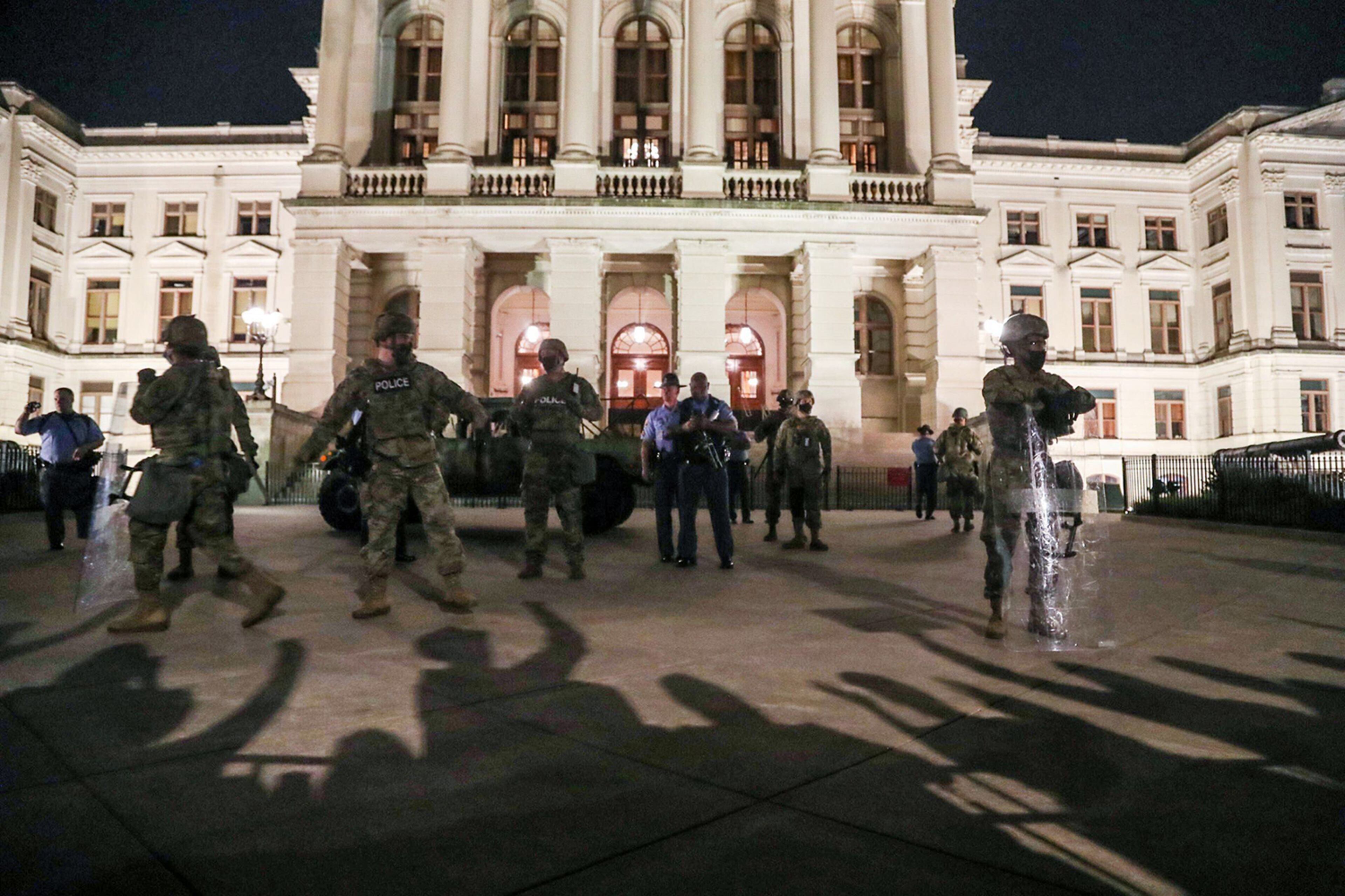 Demonstrators chant at Georgia State Patrolmen and Georgia National Guard that stand guard of the Georgia State Capitol building in Atlanta, on Wednesday, Aug. 24, 2020. (Alyssa Pointer/Alyssa.Pointer@ajc.com)