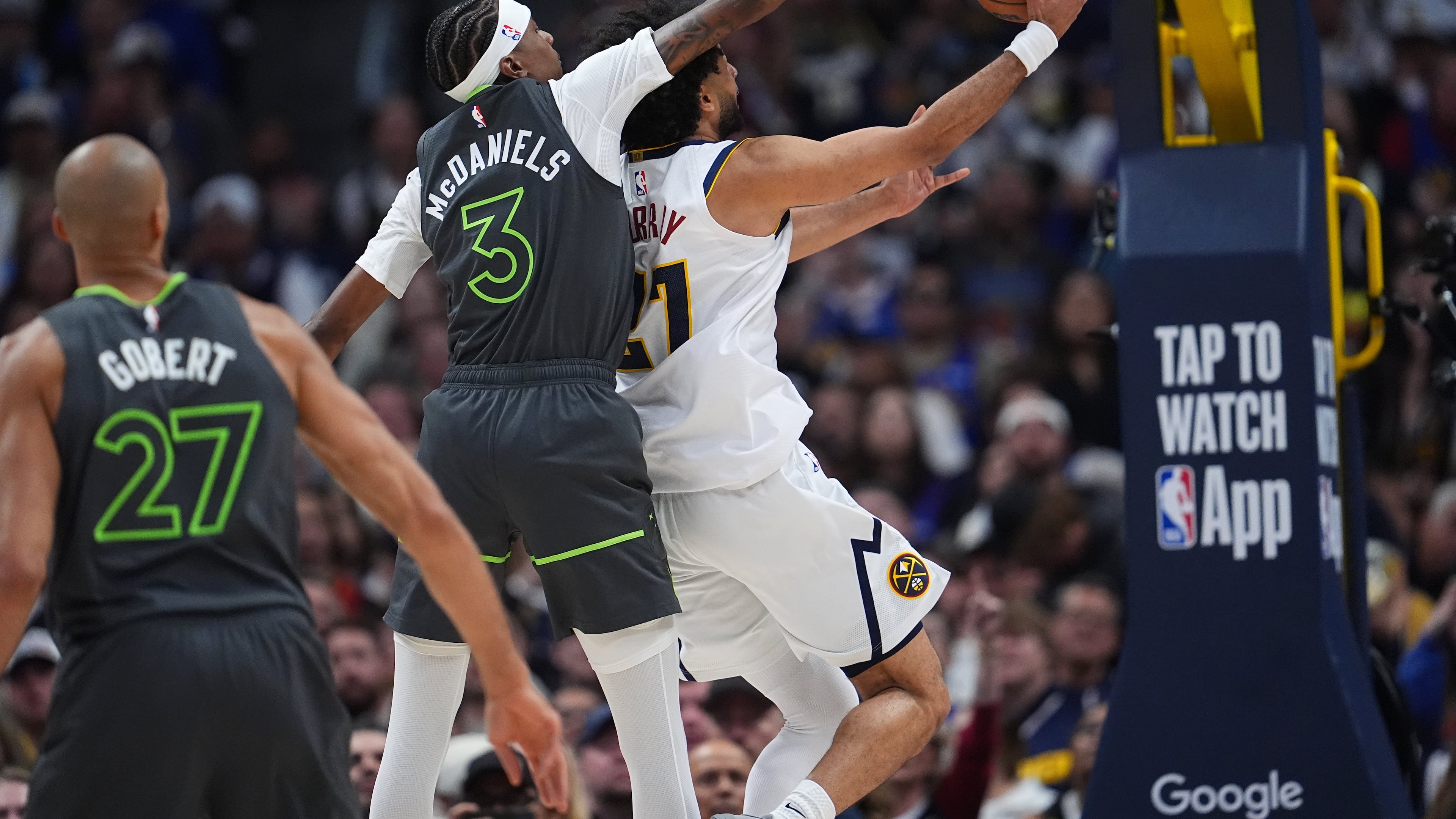 Minnesota Timberwolves forward Jaden McDaniels, left, tries to block a shot by Denver Nuggets guard Jamal Murray in the second half in Game 1 of a first-round NBA playoffs basketball series, Saturday, April 18, 2026, in Denver. (AP Photo/David Zalubowski)