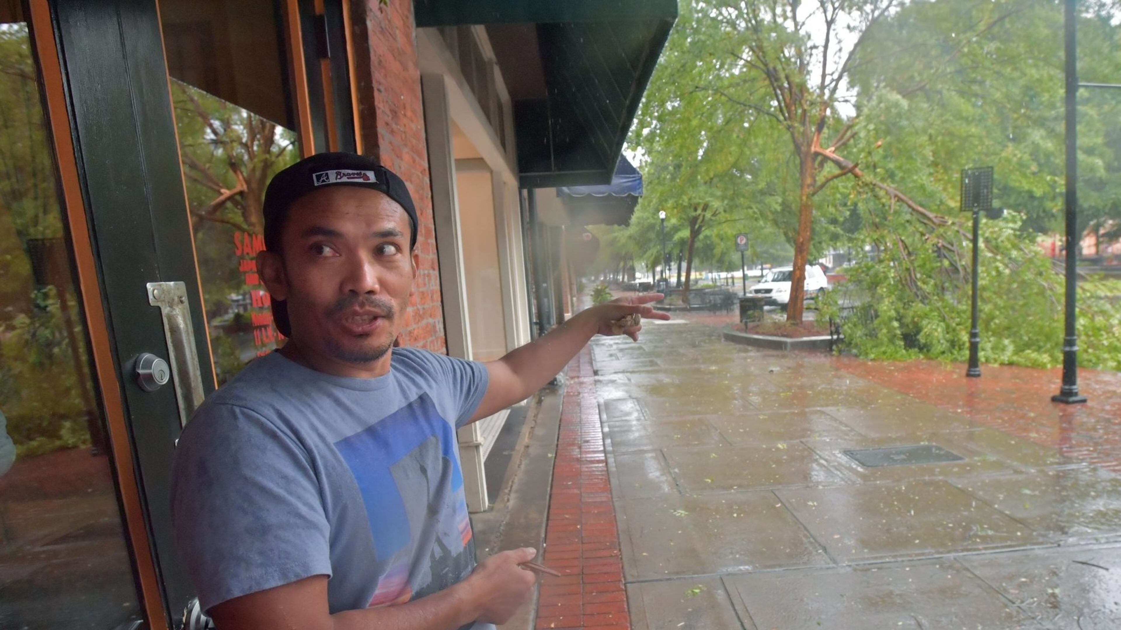 Saban Nadeak, owner of Samurai Japanese restaurant in Columbus, shows where the tree fallen onto his car on Monday. HYOSUB SHIN / HSHIN@AJC.COM