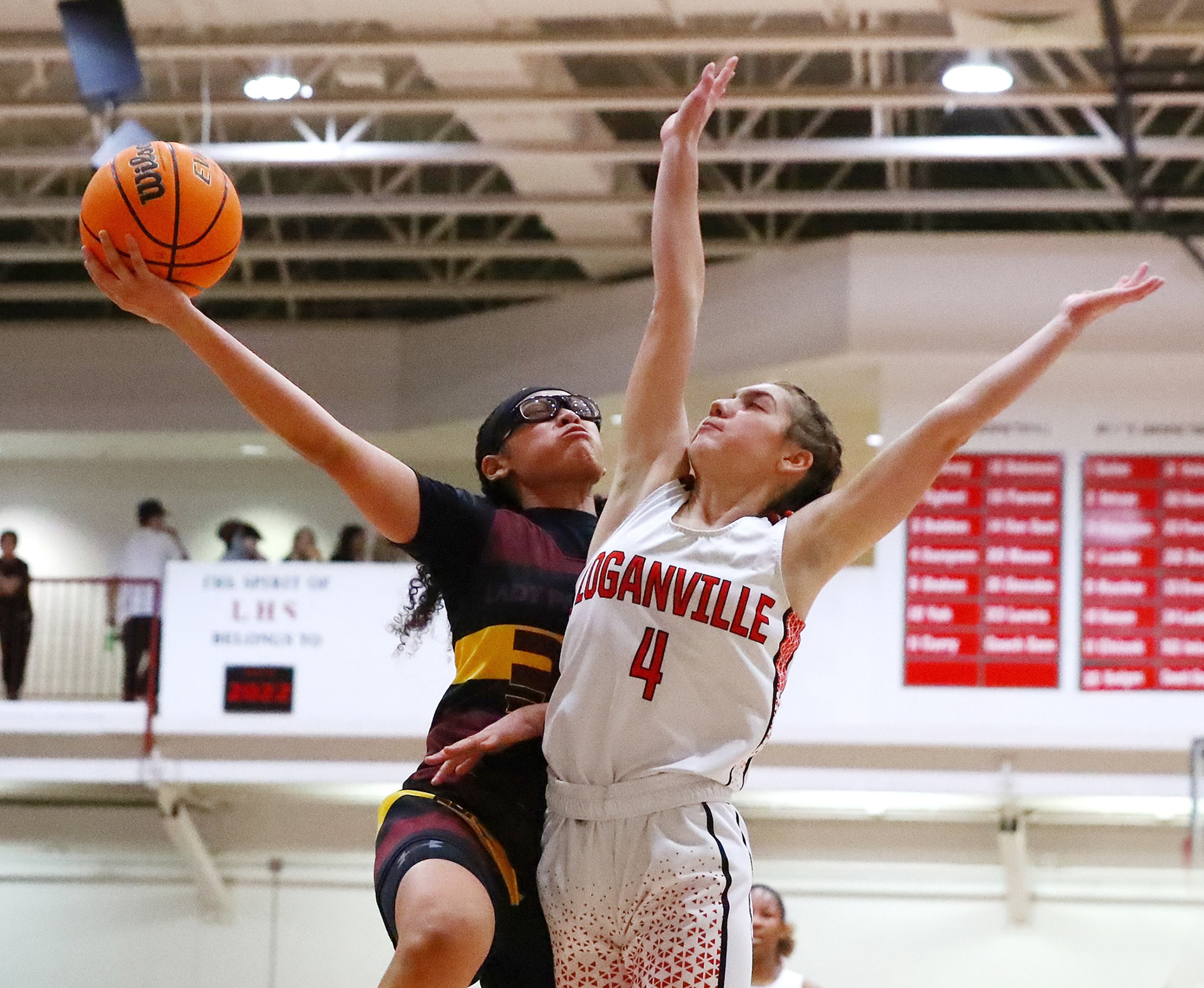 Forest Park guard Yasmine Allen goes to the basket for two against Loganville guard Rivers Sampson in their high school basketball tournament game on Wednesday, March 2, 2022, in Loganville. “Curtis Compton / Curtis.Compton@ajc.com”`