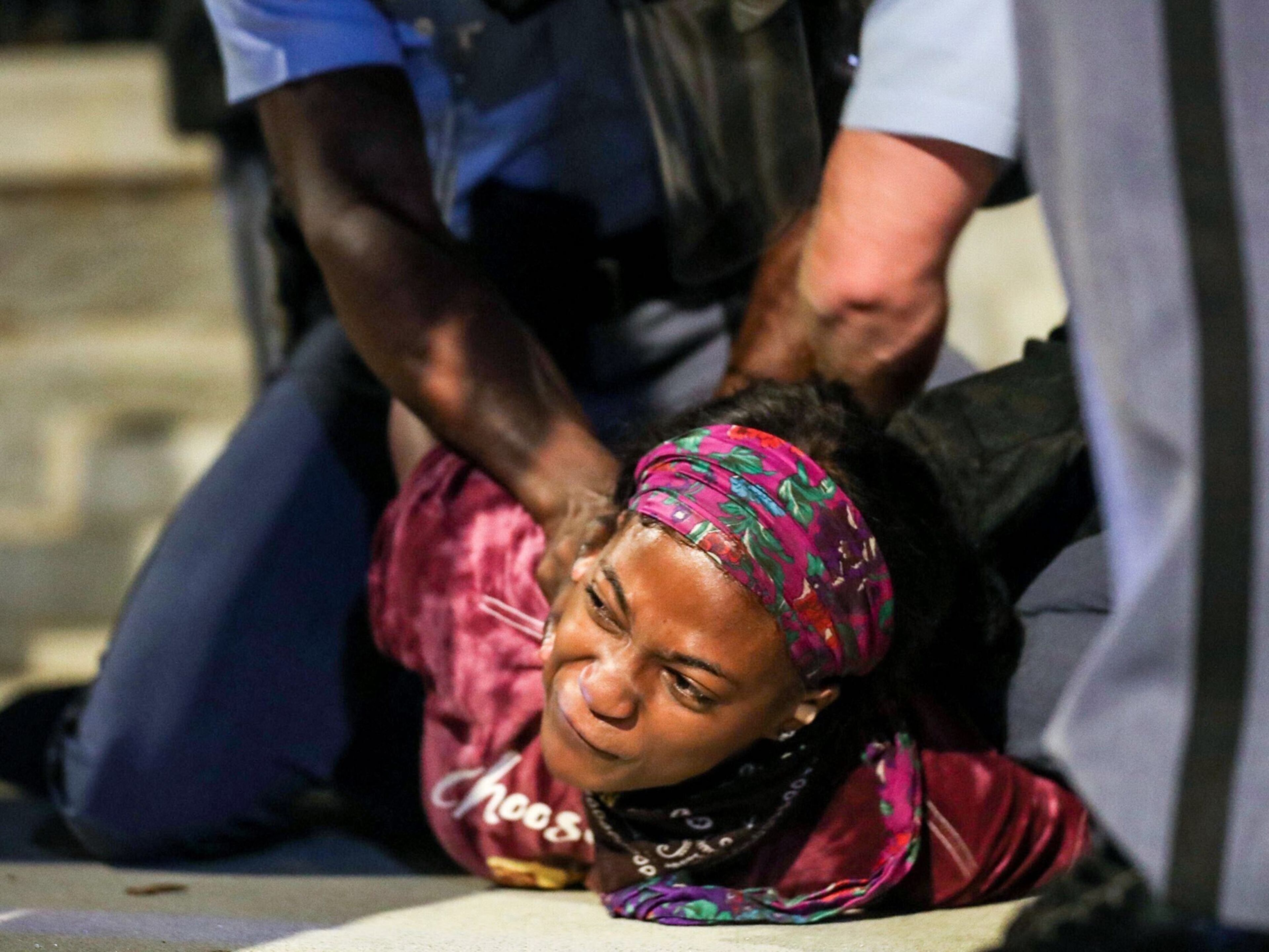 A young woman is pinned to the ground Wednesday, Sept. 23, 2020, as she is arrested by Georgia State Troopers in front of the Georgia State Capitol Building in Atlanta. Demonstrators received a three-minute warning before arrests took place. (Alyssa Pointer / Alyssa.Pointer@ajc.com)