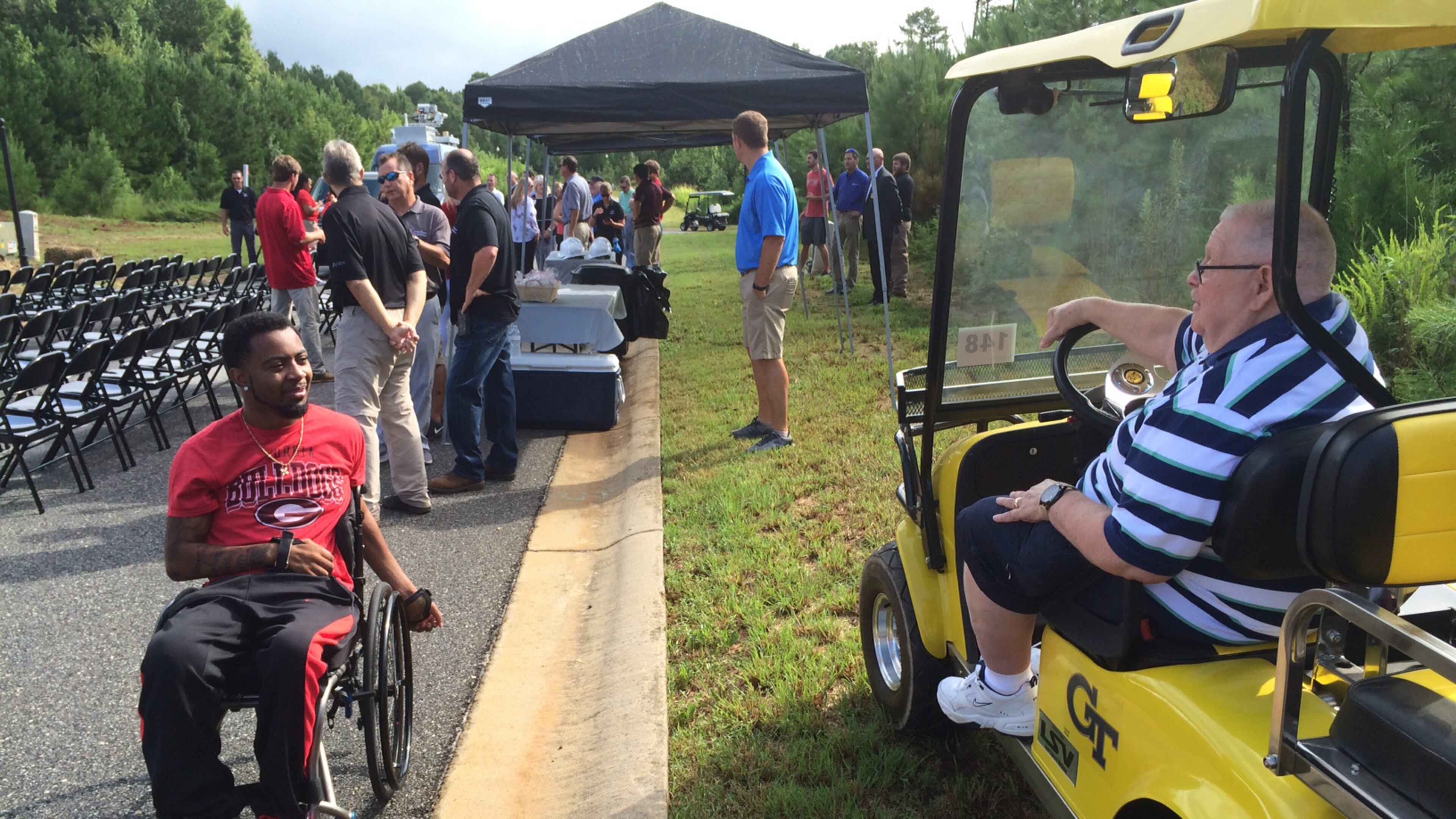 See, we all can get along: At a very Georgia-themed ground-breaking, Devon Gales meets soon-to-be neighbor Jimmy Herrin, who obviously comes from the other side of the street. (Steve Hummer/Staff)