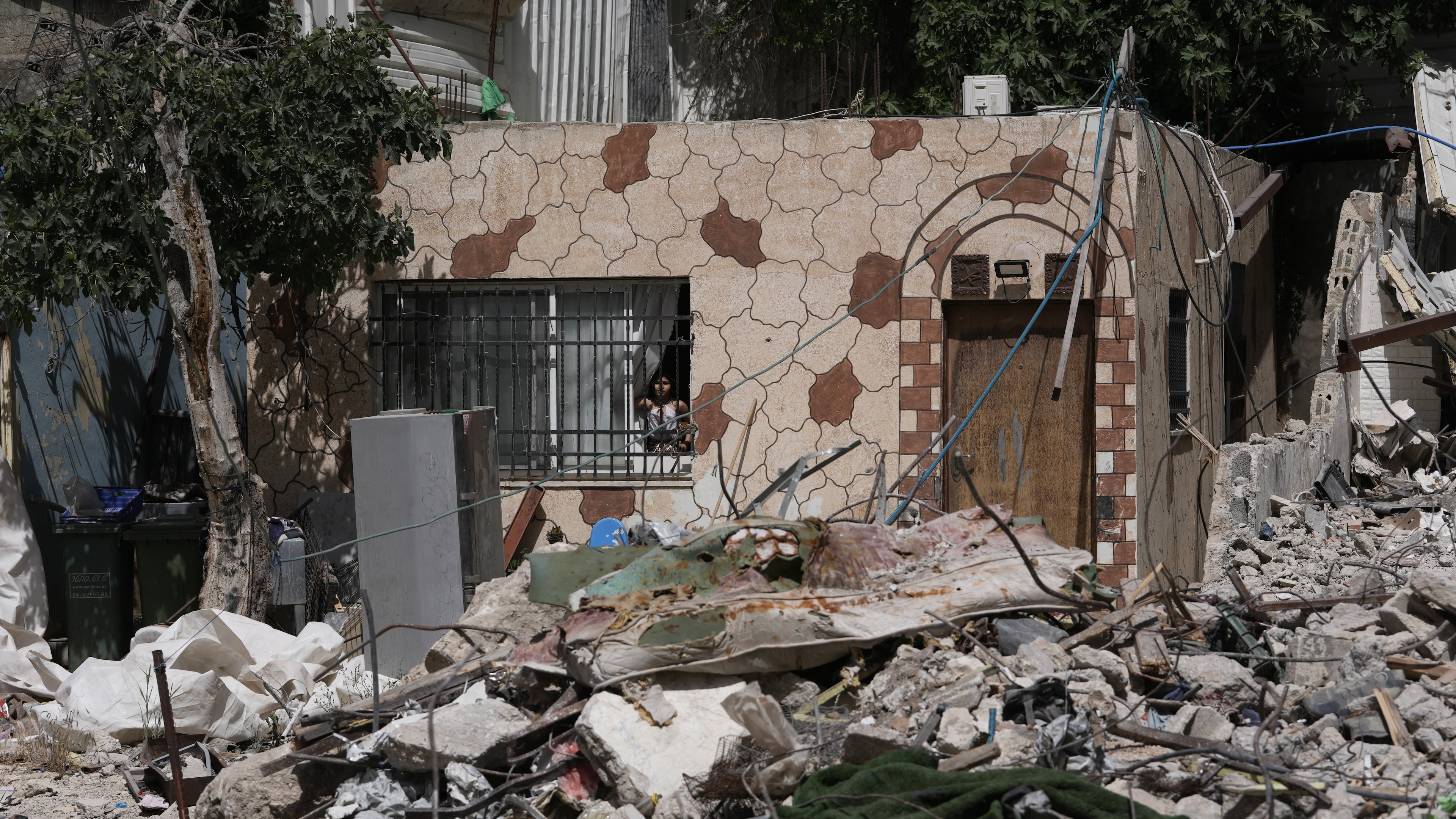 A Palestinian girl looks out a window at the rubble of a home demolished by Israeli authorities in the Silwan neighborhood of east Jerusalem, May 19, 2026. (AP Photo/Mahmoud Illean)