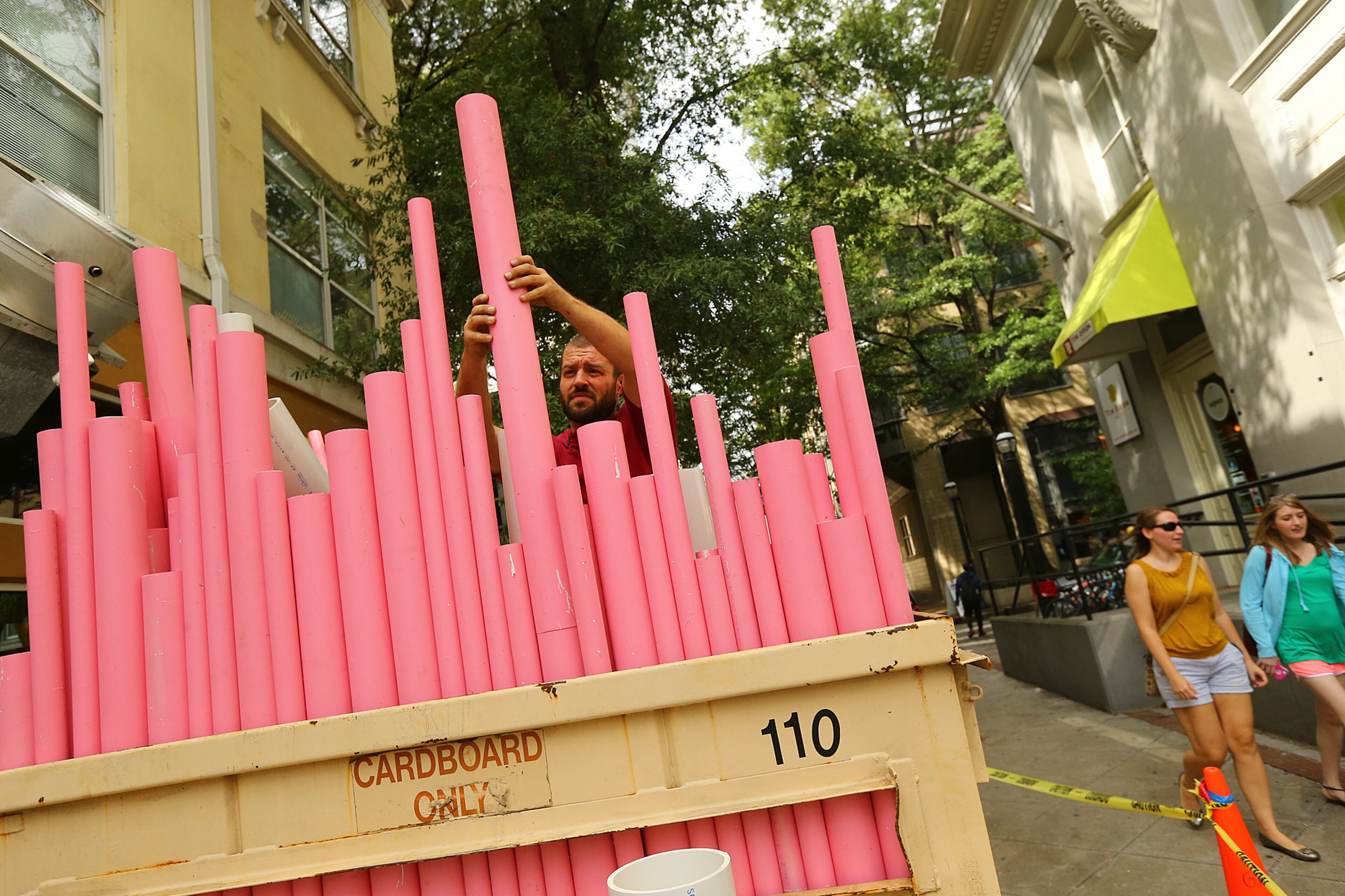 Atlanta artist Mike Black climbs into a Dumpster he is transforming into a visual arts environment called "Dumpster D(EYE)VE" Monday, Oct. 13, 2014, on Broad Street in Atlanta. 20 artists were given 10 big trash receptacles to create a work of public art that will be part of this year's Elevate, the Office of Cultural Affairs' free week-long public art event from Oct. 17-23. CURTIS COMPTON / CCOMPTON@AJC.COM