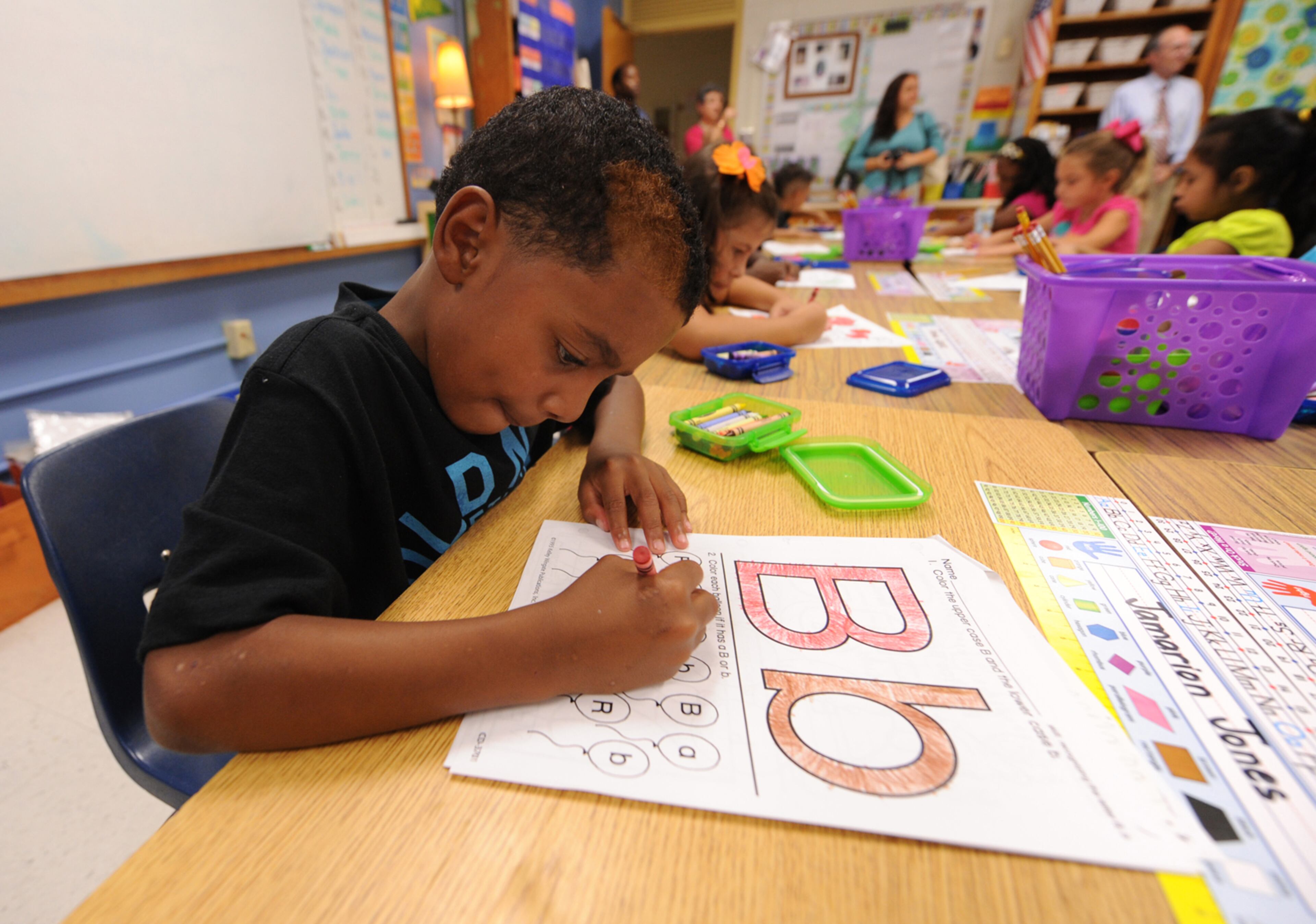 Jamarion Jones concentrates as he colors the letter B and things that start with the letter B on the first day of school at Midvale Elementary on Monday, August 12, 2013. JOHNNY CRAWFORD / JCRAWFORD@AJC.COM