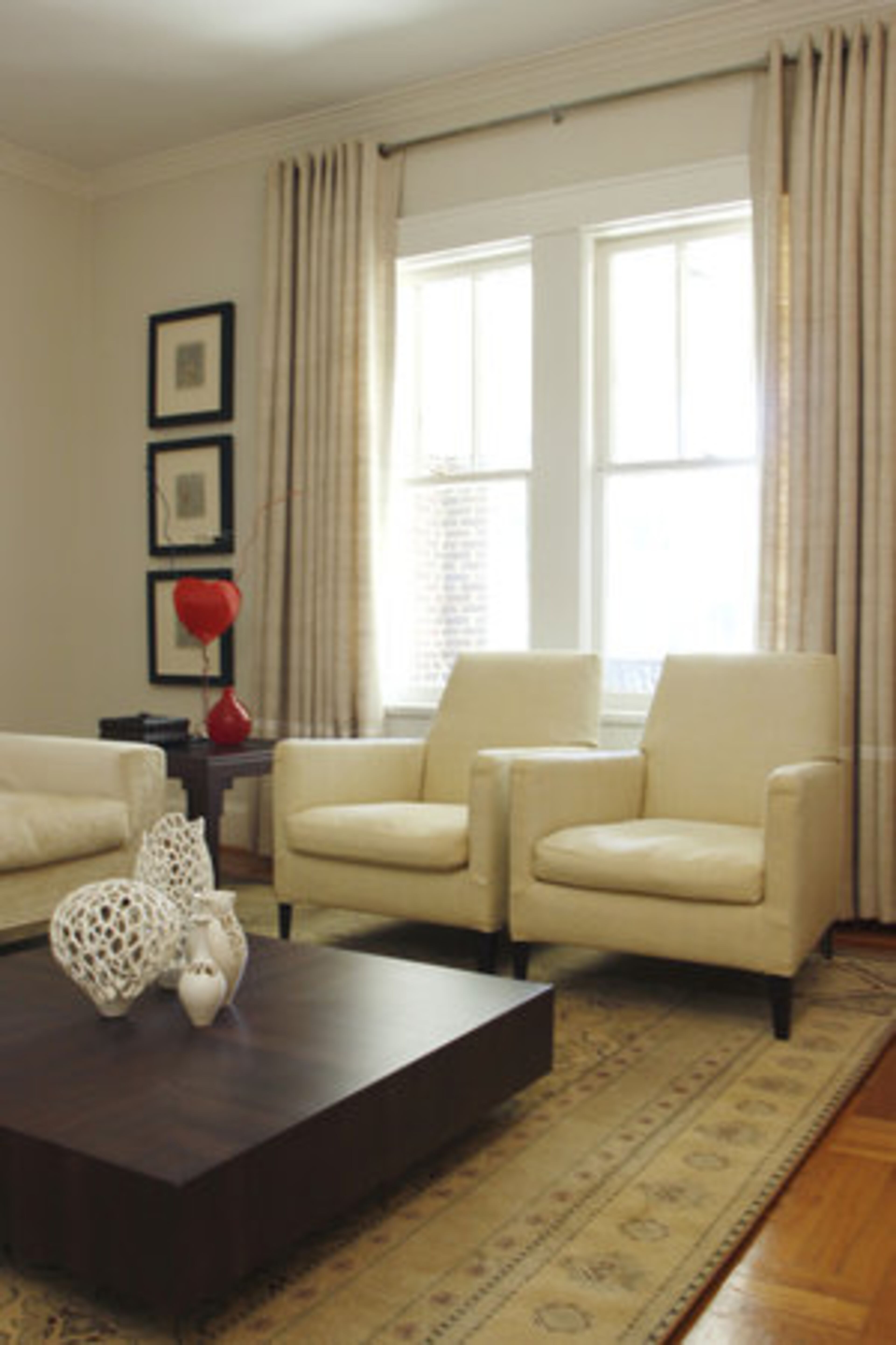 The living room features chairs covered with woven paper by B&B Italia, a cotton and linen sofa along with Life Table, both by Minotti and found at Space, a heart-shaped lamp by Ingo Maurer and vases by Venini.