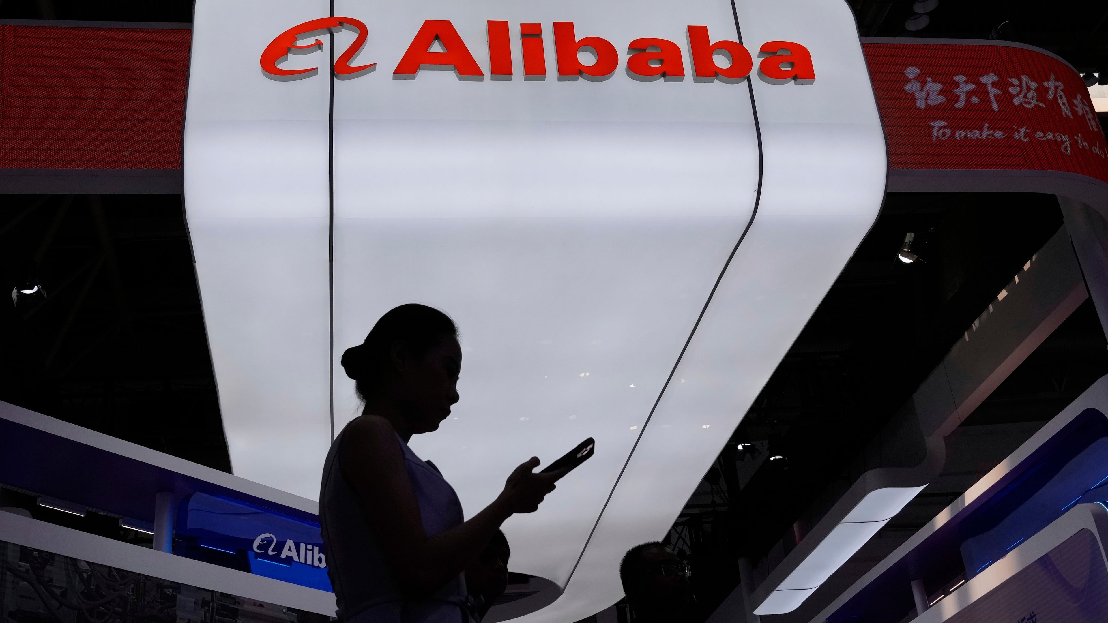 FILE - A visitor walks in front of Alibaba booth during the 3rd China International Supply Chain Expo at the China International Exhibition Center, in Beijing, China, Friday, July 18, 2025. (AP Photo/Mahesh Kumar A., File)