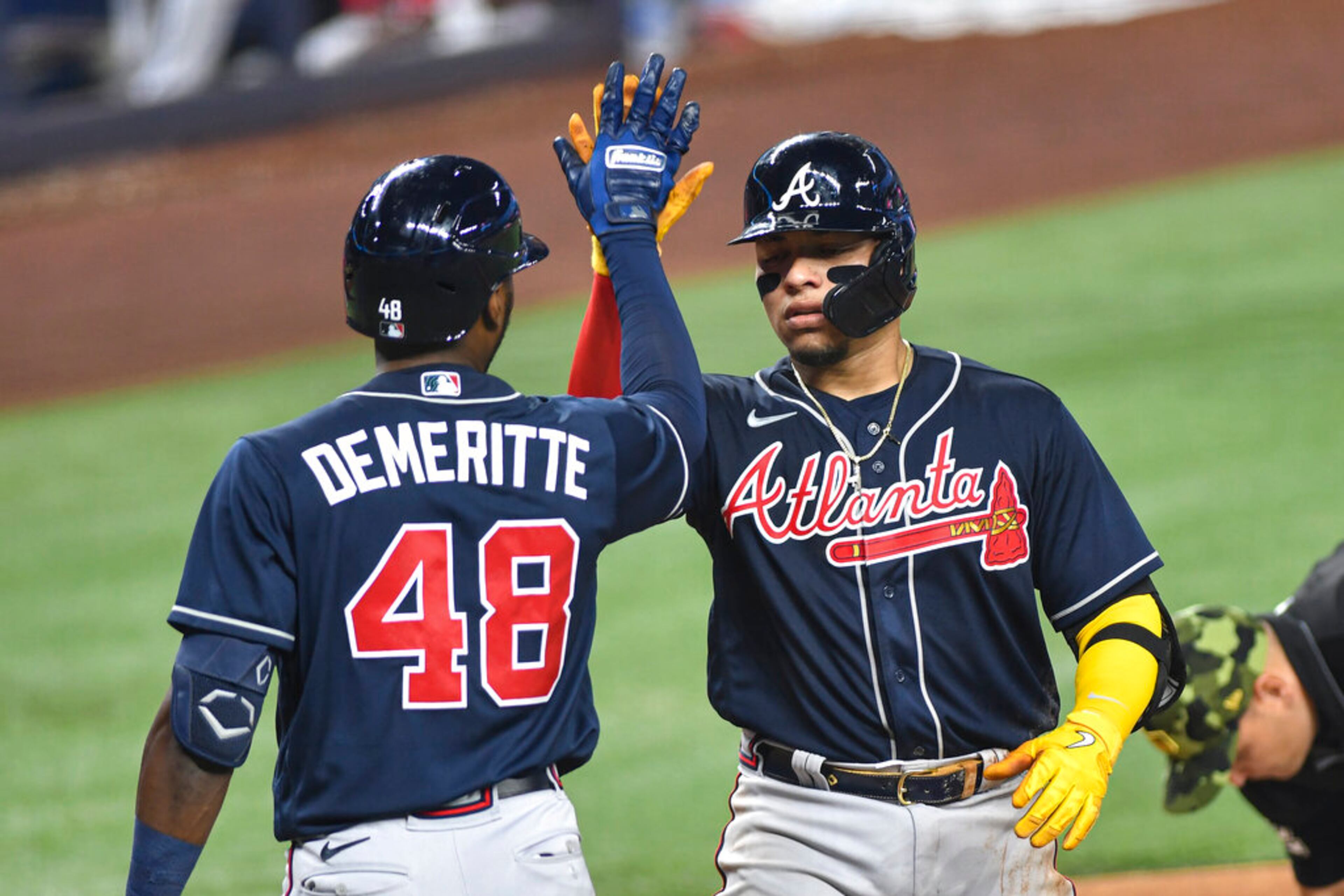Atlanta Braves' William Contreras celebrates with Travis Demeritte after hitting a solo homerun during the fifth inning of the team's baseball game against the Miami Marlins, Saturday May 21, 2022, in Miami. (AP Photo/Gaston De Cardenas)