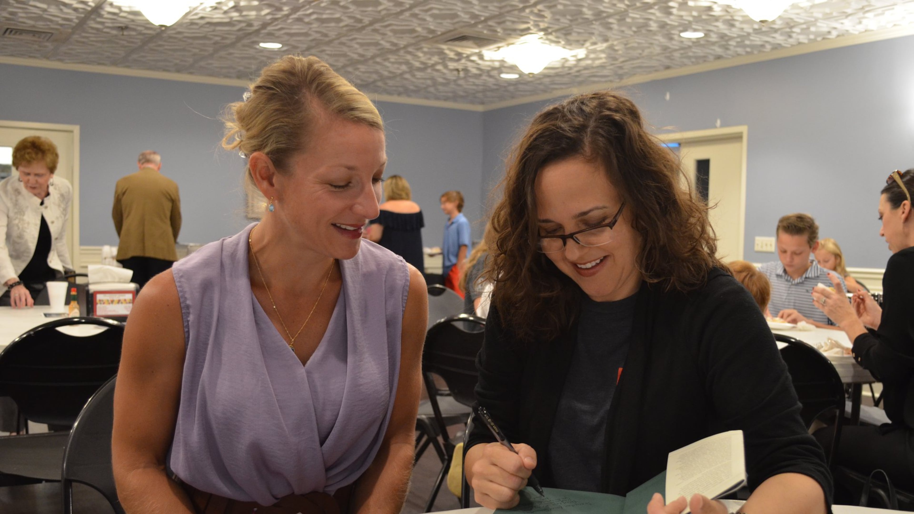 Sarah Stanley Fallaw of Marietta signs a copy of “The Next Millionaire Next Door” for a fan. Fallaw is the daughter of the late best-selling author Thomas J. Stanley. CONTRIBUTED