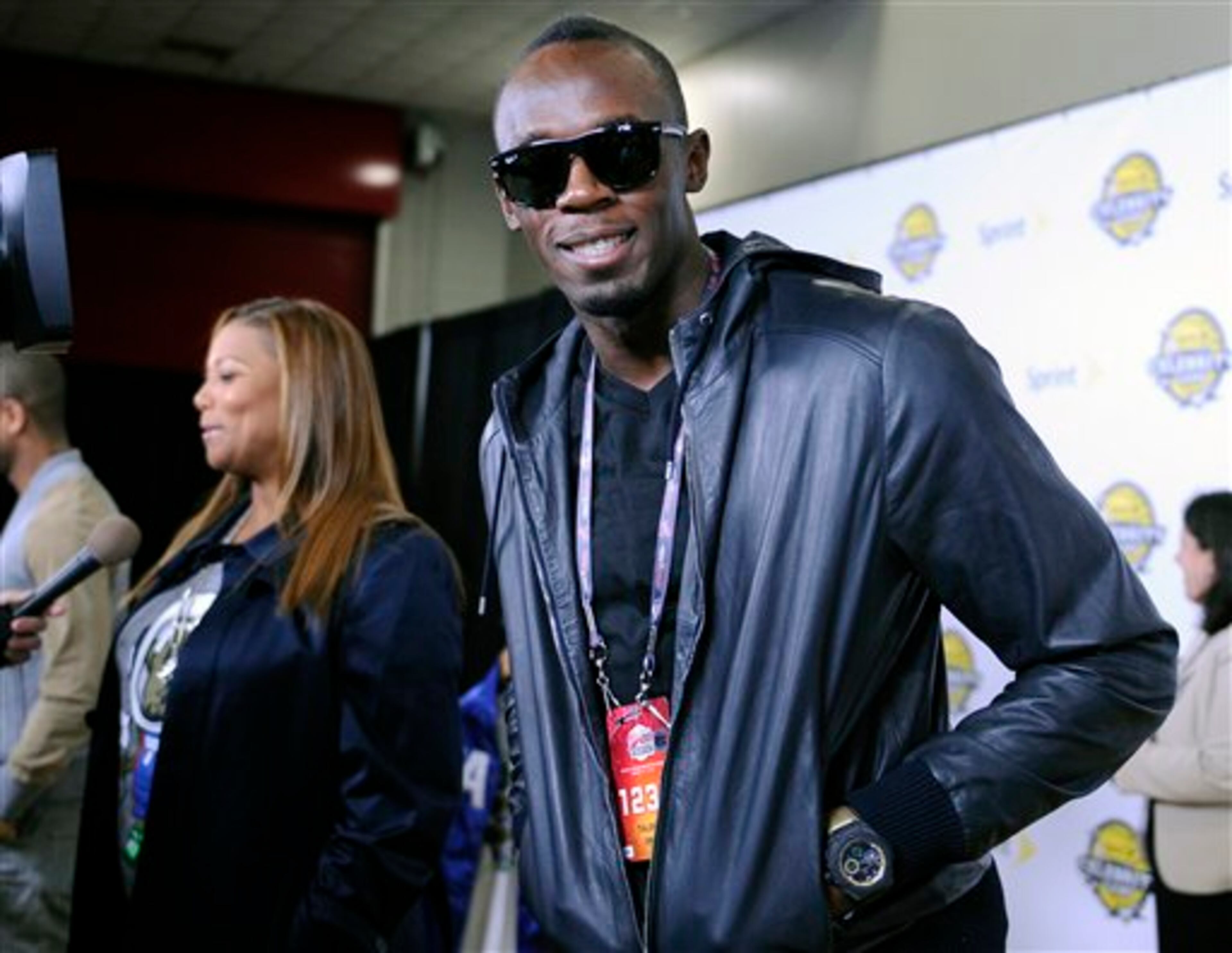 Olympic gold medalist Usain Bolt, right, and singer/actress Queen Latifah arrive at the NBA All-Star celebrity game Friday, Feb. 15, 2013, in Houston. (AP Photo/Pat Sullivan)