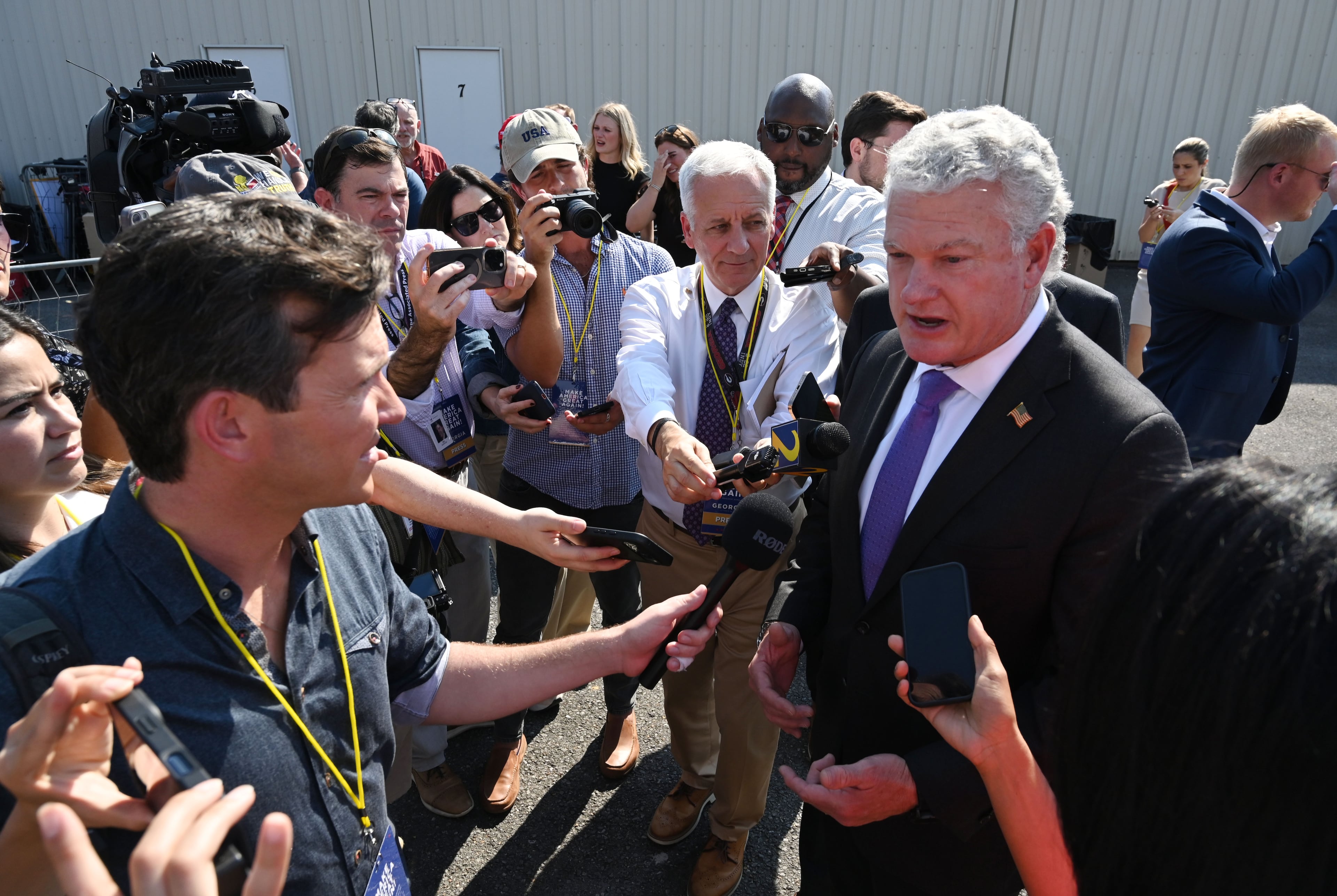 U.S. Rep. Mike Collins speaks to reporters before a campaign rally at Dalton Municipal Airport last week. (Hyosub Shin/AJC)