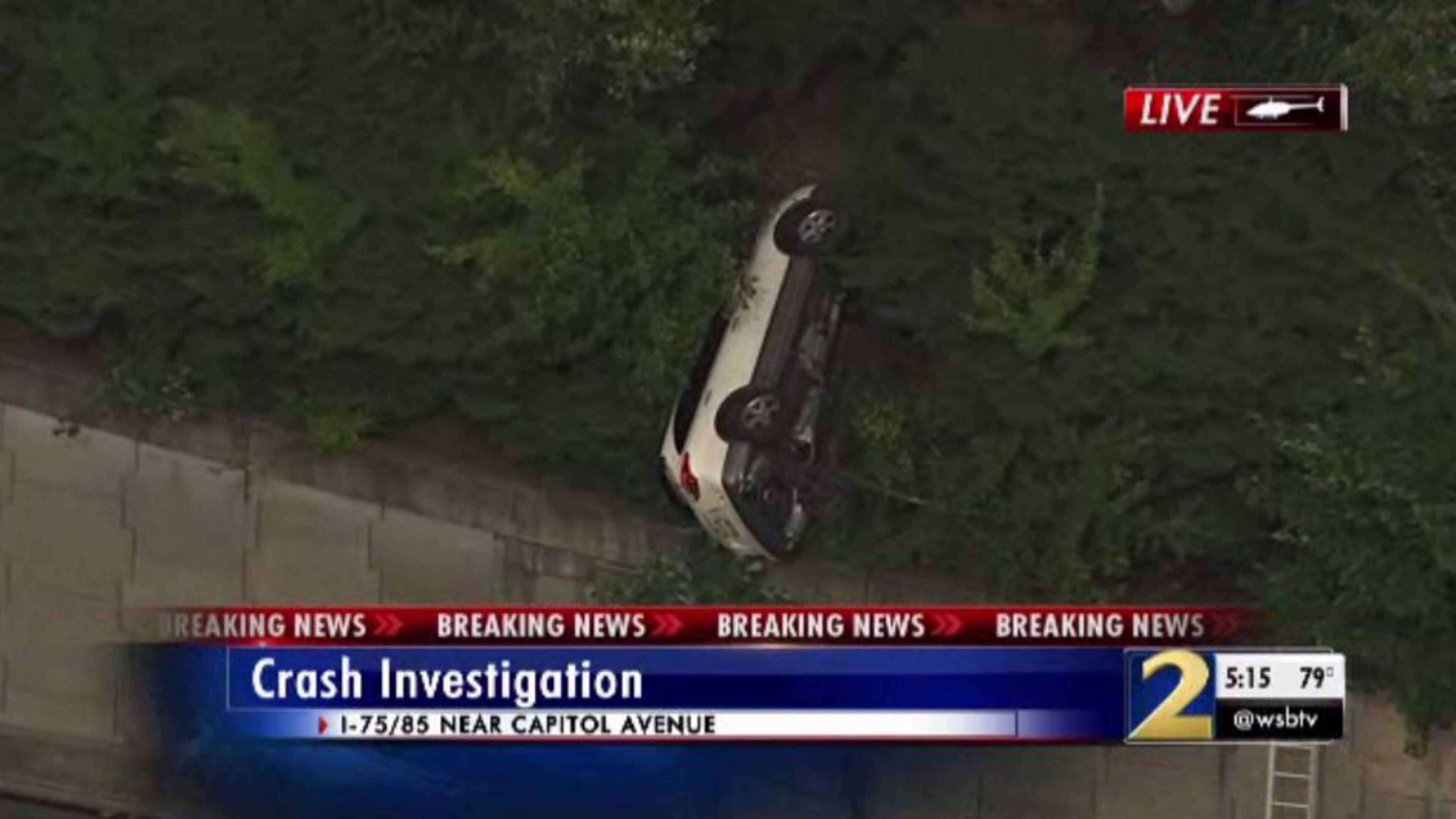 An overturned vehicle was dangling on the ledge of the I-20 westbound ramp to the Downtown Connector northbound in Atlanta on Tuesday.