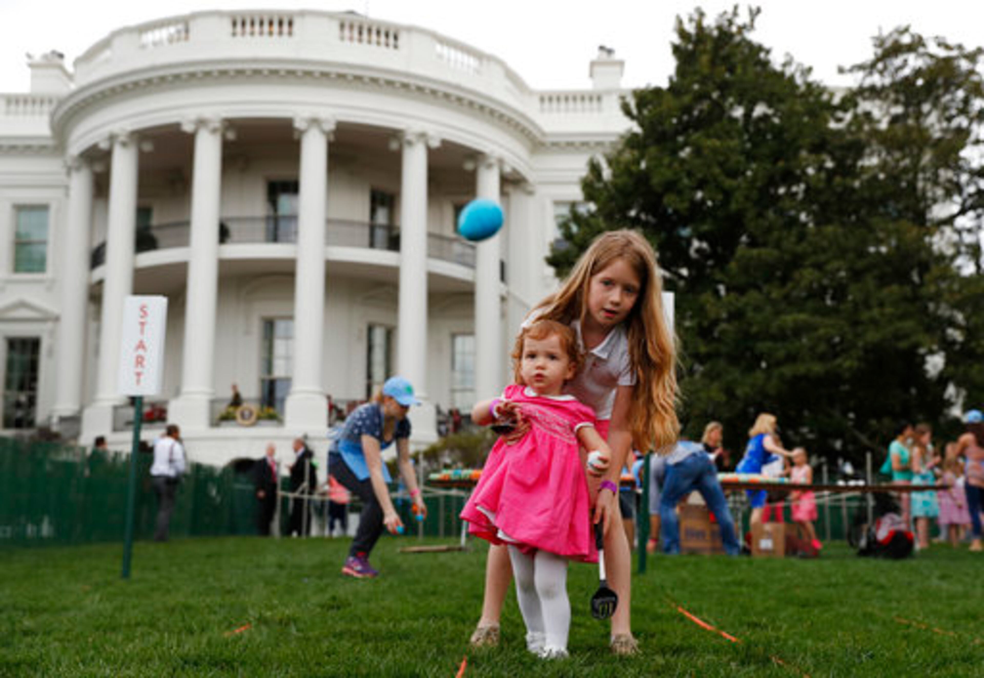 Eggs fly as Caroline Earnshaw, 10, helps her sister Brooke Earnshaw, 2, during the White House Easter Egg Roll on the South Lawn of the White House in Washington, Monday, April,17, 2017. President Donald Trump and first lady Melania Trump are set to host the official annual Easter egg roll at the White House.(AP Photo/Carolyn Kaster)