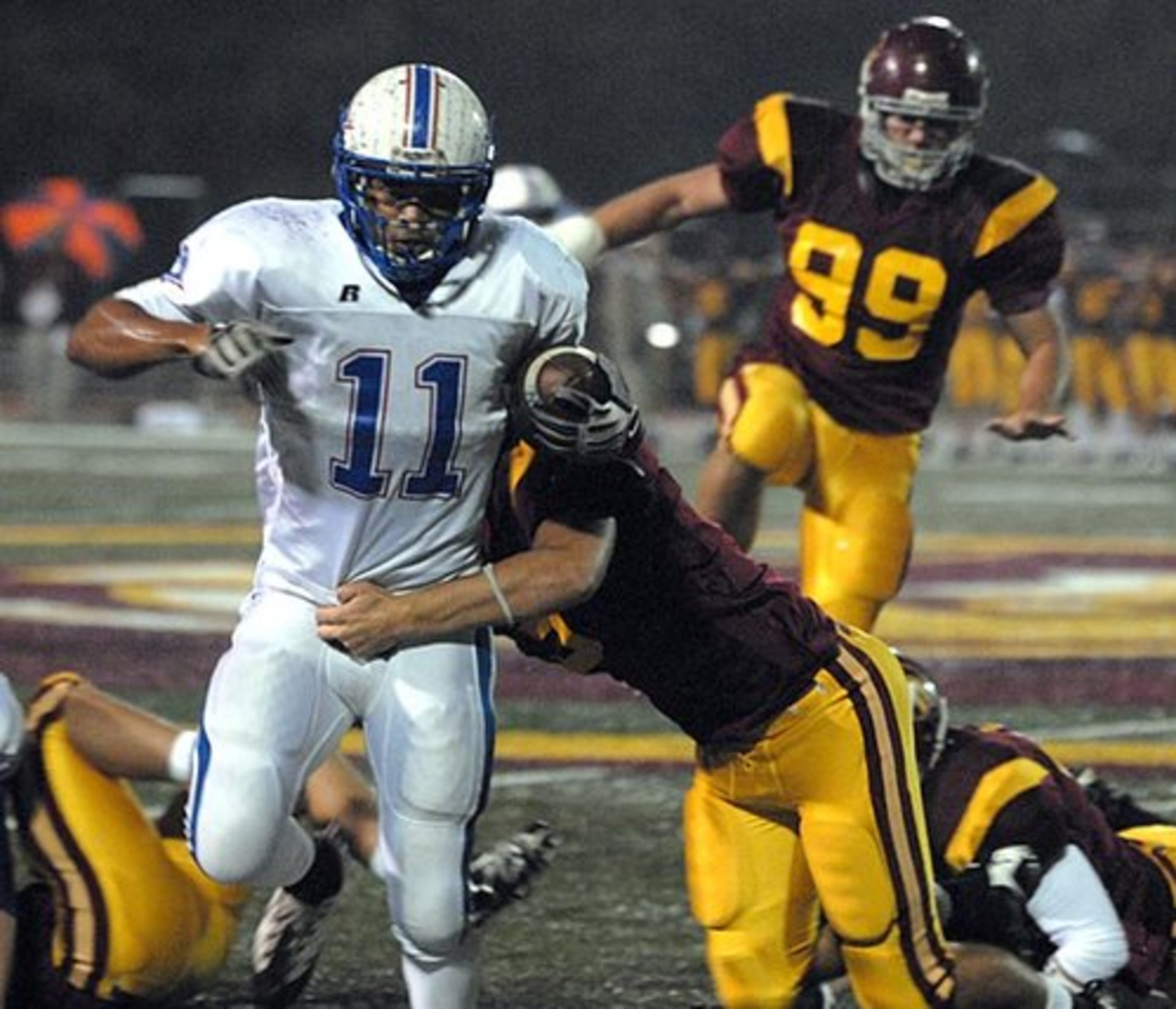 Walton High's Michael Boydston (No. 11) tries to escape Lassiter's defense during the first quarter Friday night in Marietta. The Lassiter High Trojans hosted the Walton Raiders.