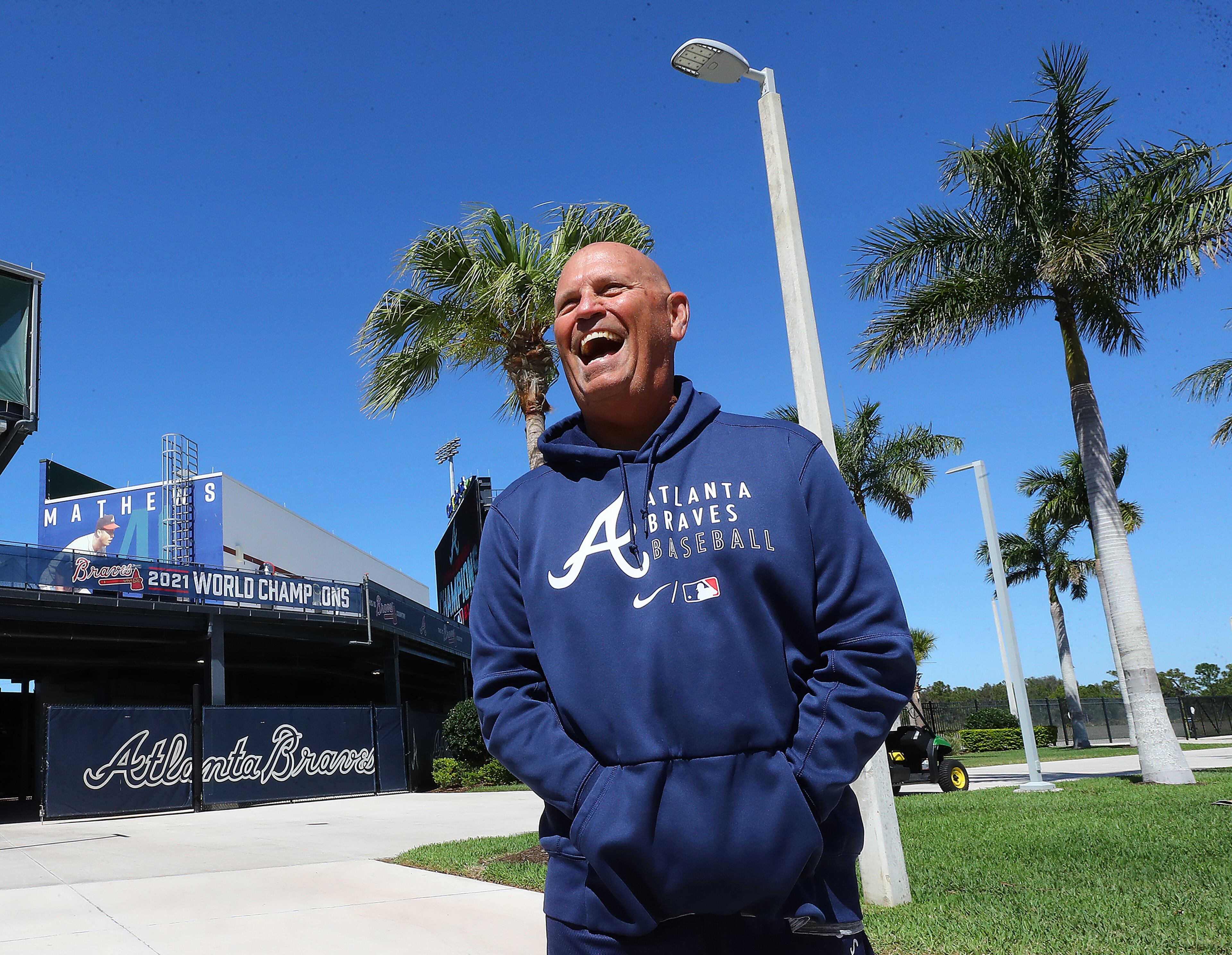 Braves manager Brian Snitker shares a laugh as he arrives for his press conference the day players have to report for spring training at CoolToday Park on Sunday, March 13, 2022, in North Port. The team’s first official workout is scheduled for Monday. “Curtis Compton / Curtis.Compton@ajc.com”`