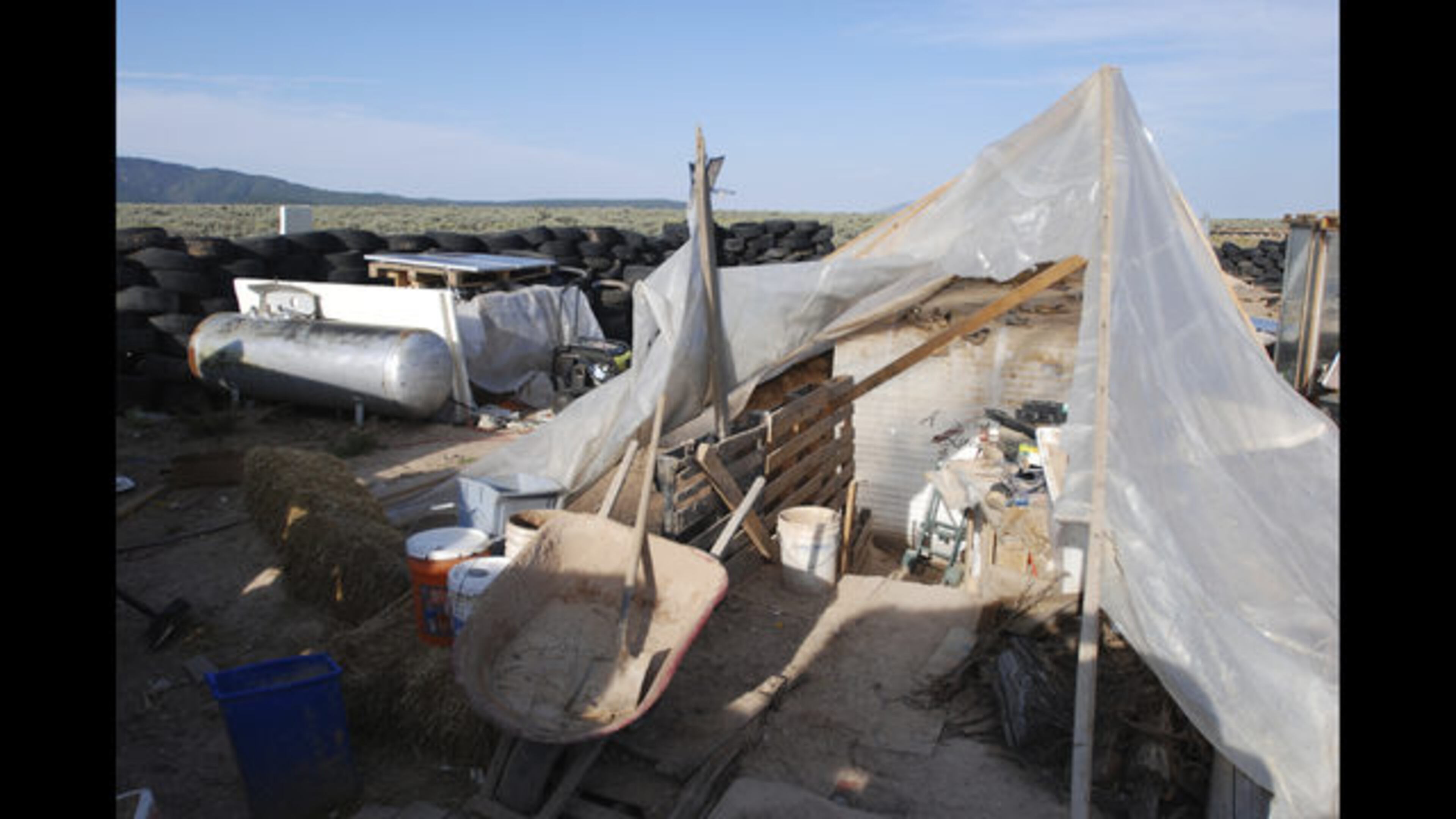 Various items litter a squalid makeshift living compound in Amalia, N.M., on Friday, Aug. 10, 2018, where five adults were arrested on child abuse charges and remains of a boy were found. (AP Photo/Morgan Lee) </p>