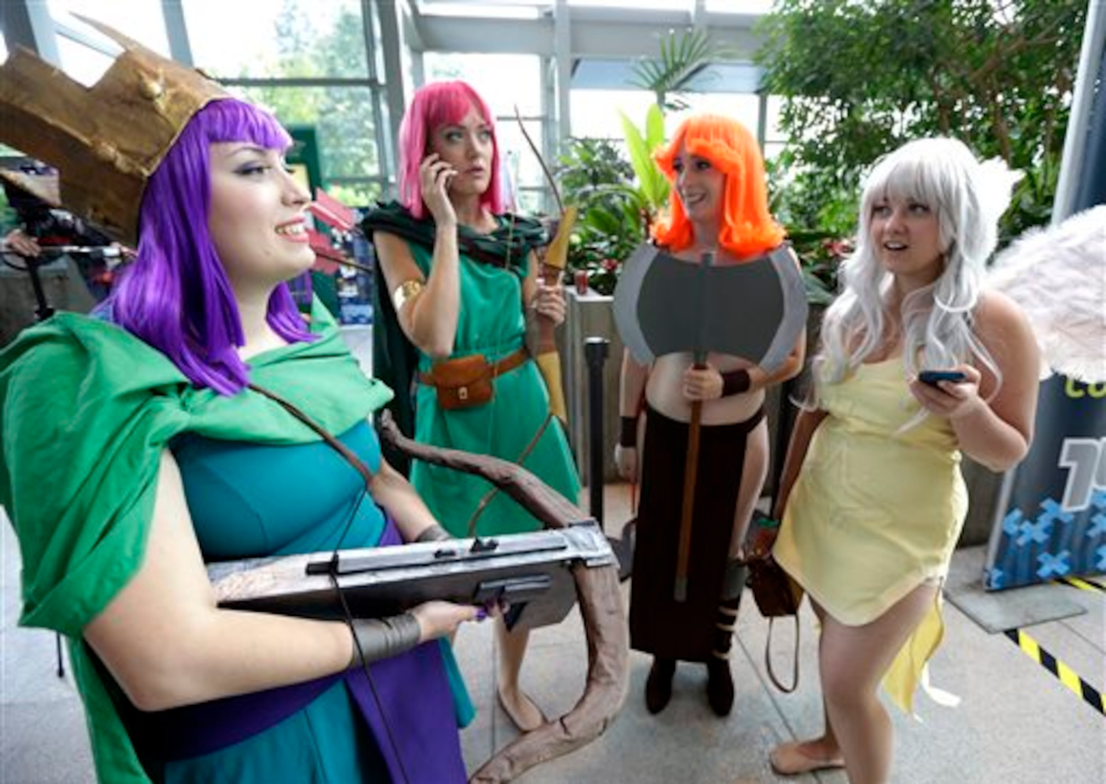 Dressed as characters with different battle skills from the video game Clash of Clans, from left, Liz Leo, Kristina Horner, Jenn Godwin and Eia Waltzer stand together Friday, Aug. 29, 2014, at the Penny Arcade Expo, a fan-centric celebration of gaming in Seattle. The event is expected to be attended by roughly 85,000 gamers and will include concerts, game tournaments and previews of upcoming titles. (AP Photo/Ted S. Warren)