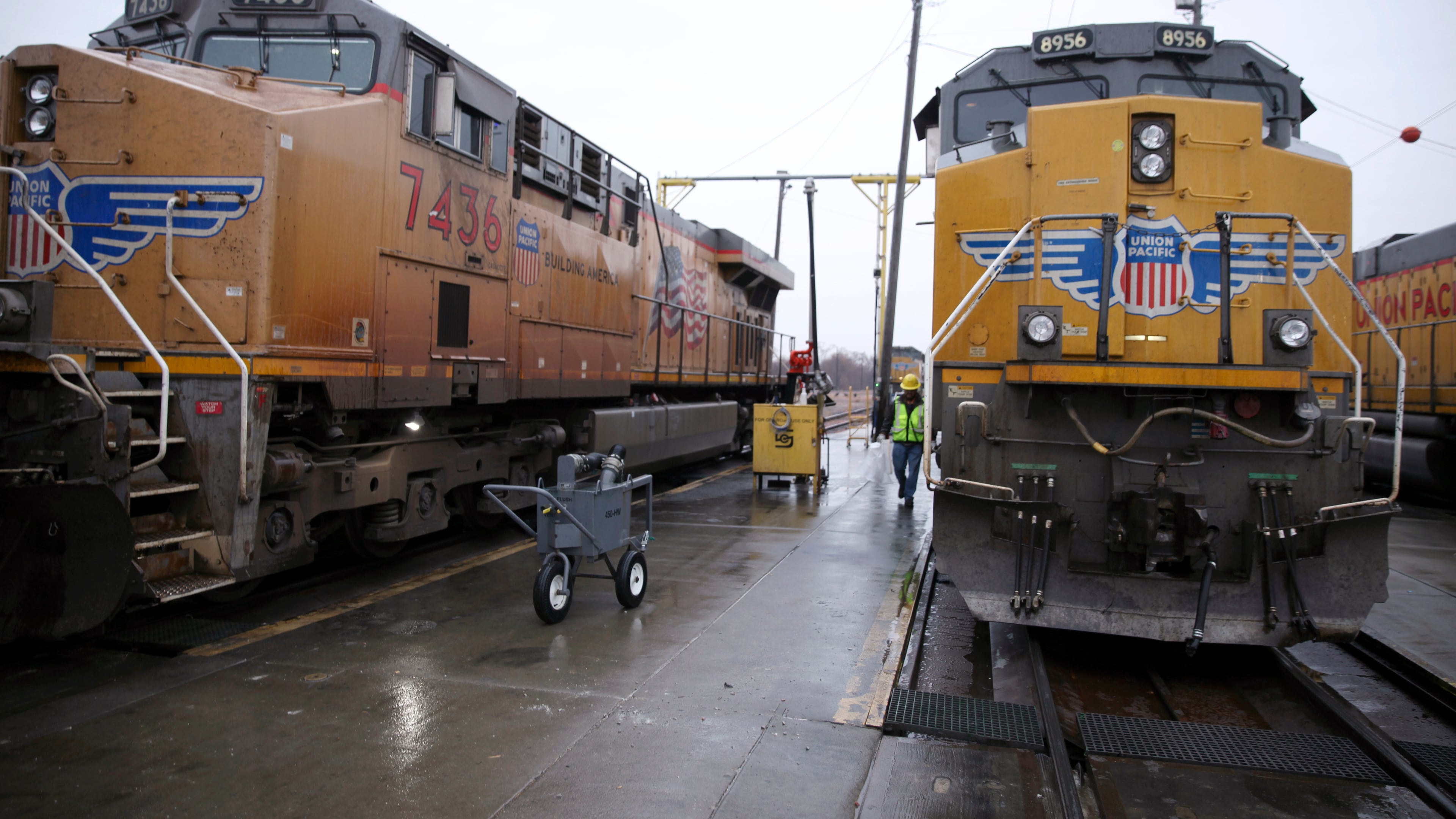 FILE - A Union Pacific worker walks between two locomotives that are being serviced in a railyard in Council Bluffs, Iowa, on Dec. 15, 2023. (AP Photo/Josh Funk, File)