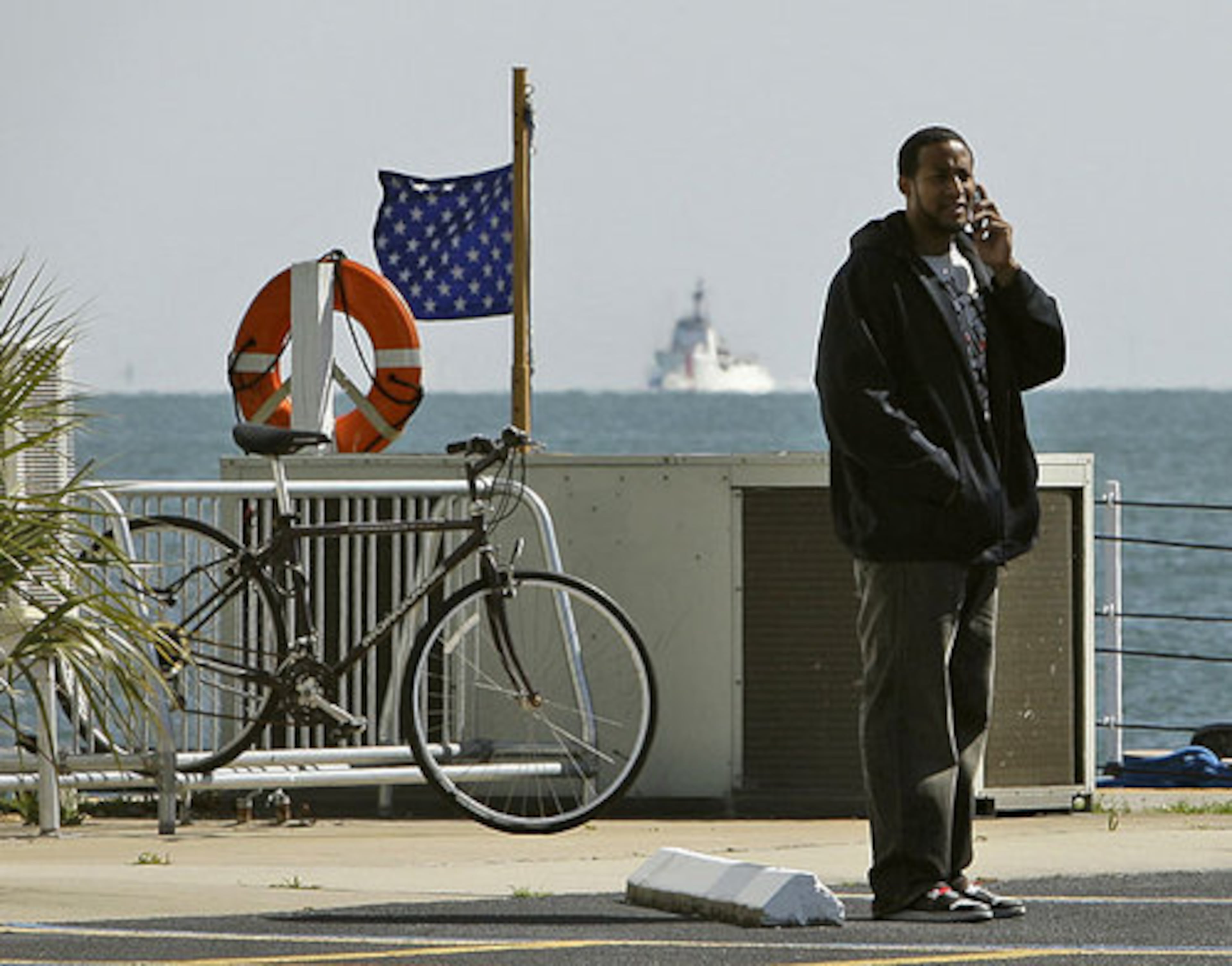Ray Sanchez, cousin of NFL football player Marquis Cooper, talks on a cell phone, as the search continues.