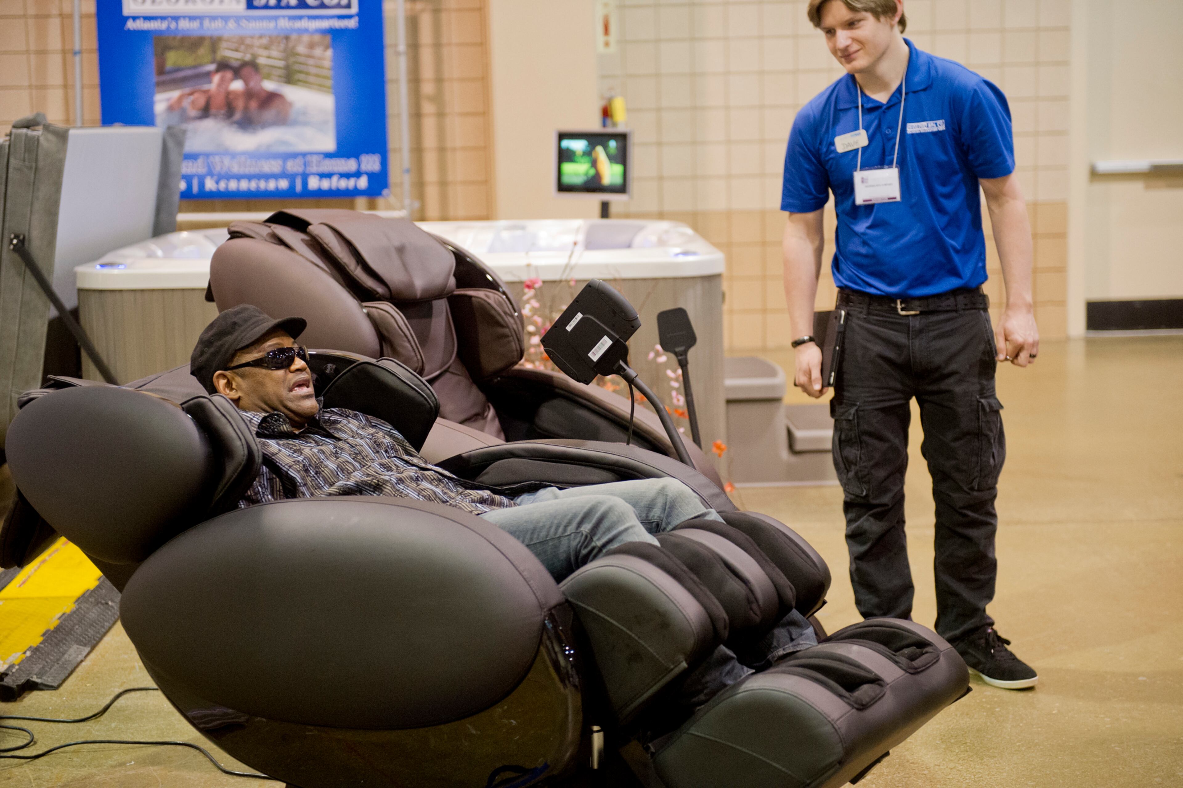 Juaderro Dowd (left) sits in a massaging chair as he talks over options with David Campbell. In its 17th year, the North Atlanta Home Show attracted 150 different home improvement companies and was projected to have over 10,000 attendees. JONATHAN PHILLIPS / SPECIAL