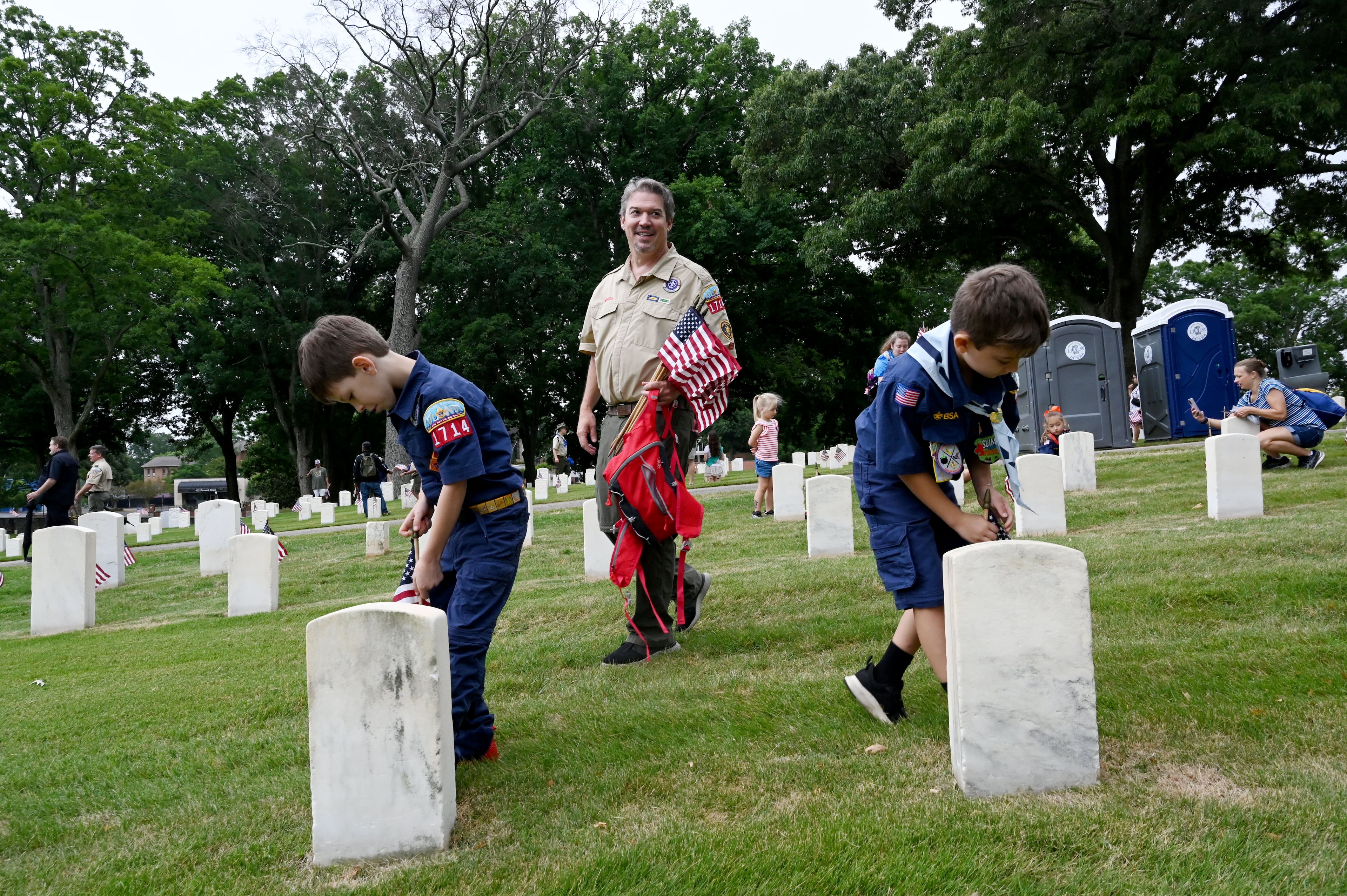 Max Cox, 9, left, and Jalen Backus, 7, place a flag in front of a headstone during the Memorial Day Flag Placement event at Marietta National Cemetery on Saturday, May 23, 2026, in Marietta. Scouting groups in the community place more than 18,000 U.S. veteran grave flags at Marietta National Cemetery each year on the Saturday before Memorial Day, helping prepare for Monday’s ceremony. The long-running service project—organized with the National Memorial Day Association of Georgia—also gives youth and adults an opportunity to honor fallen service members and learn about their sacrifices and the area’s history. (Hyosub Shin/AJC)