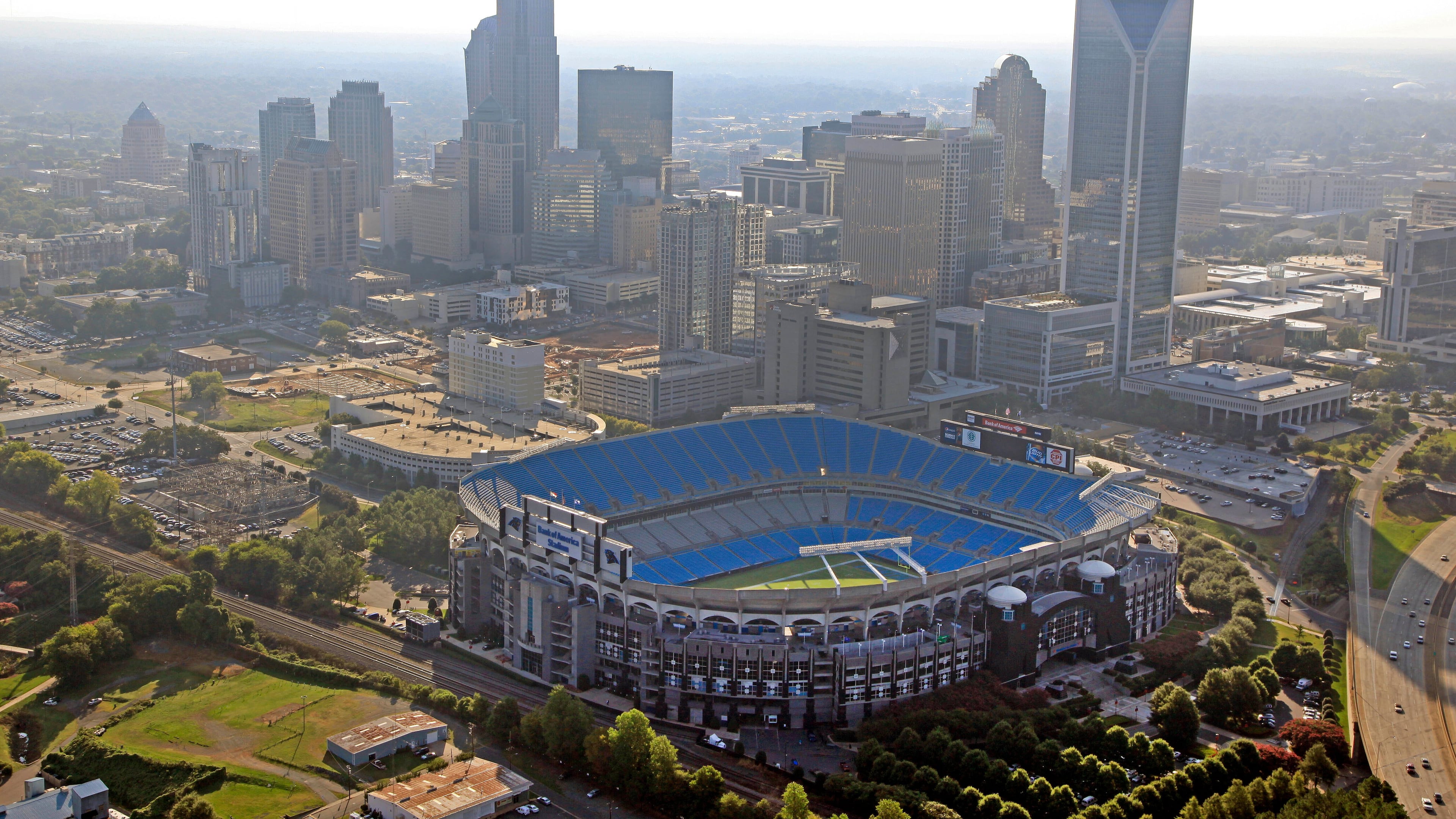 FILE - In this Aug. 16, 2012 file photo, the skyline of Charlotte, N.C., rises behind Bank of America Stadium in this aerial photo. (AP Photo/Chuck Burton, File)