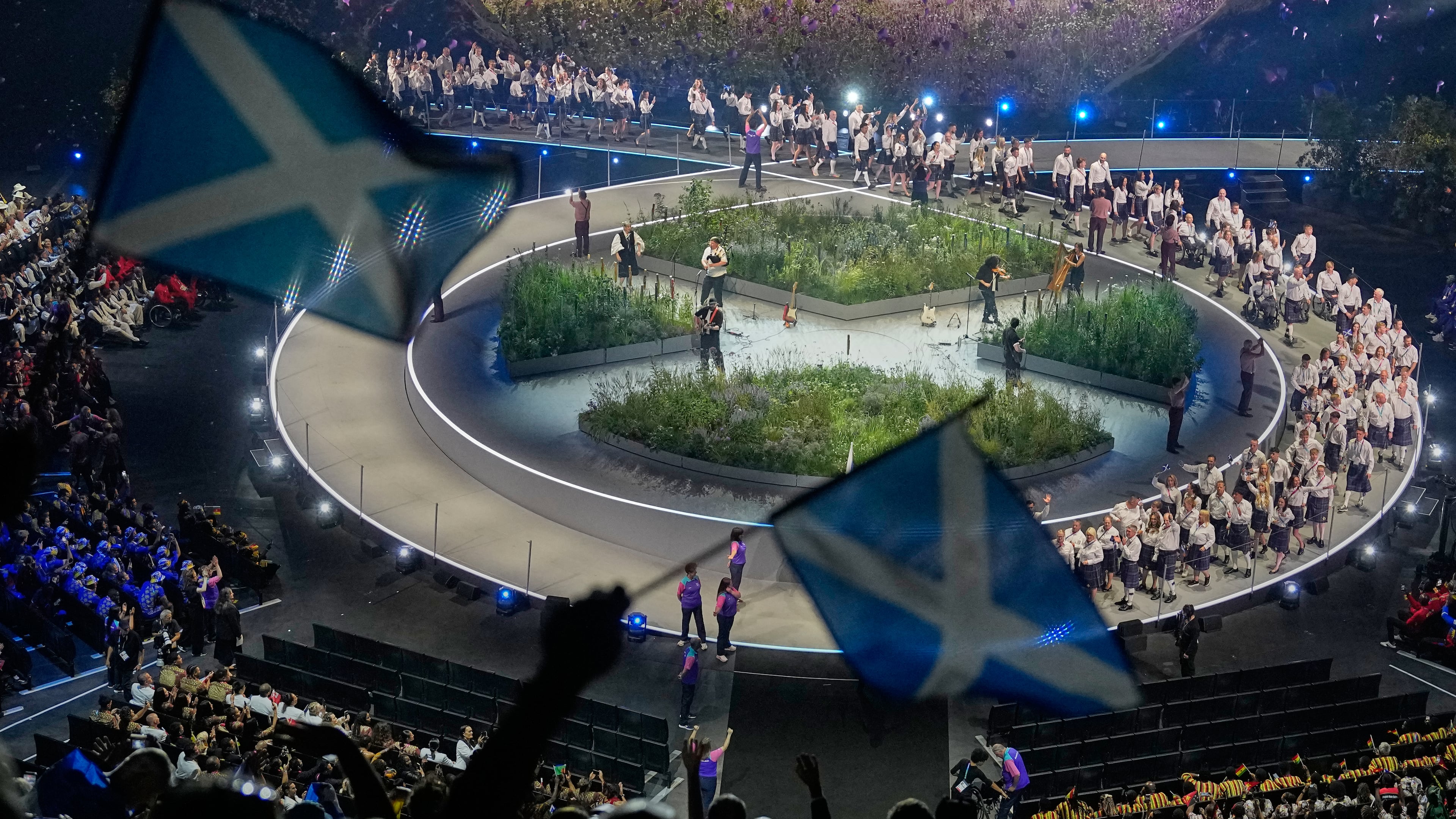 Scottish flags are waved by fans as the Scotland team arrives on stage during the Commonwealth Games opening ceremony in Glasgow, Scotland, Thursday, July 23, 2026. (AP Photo/Manish Swarup)