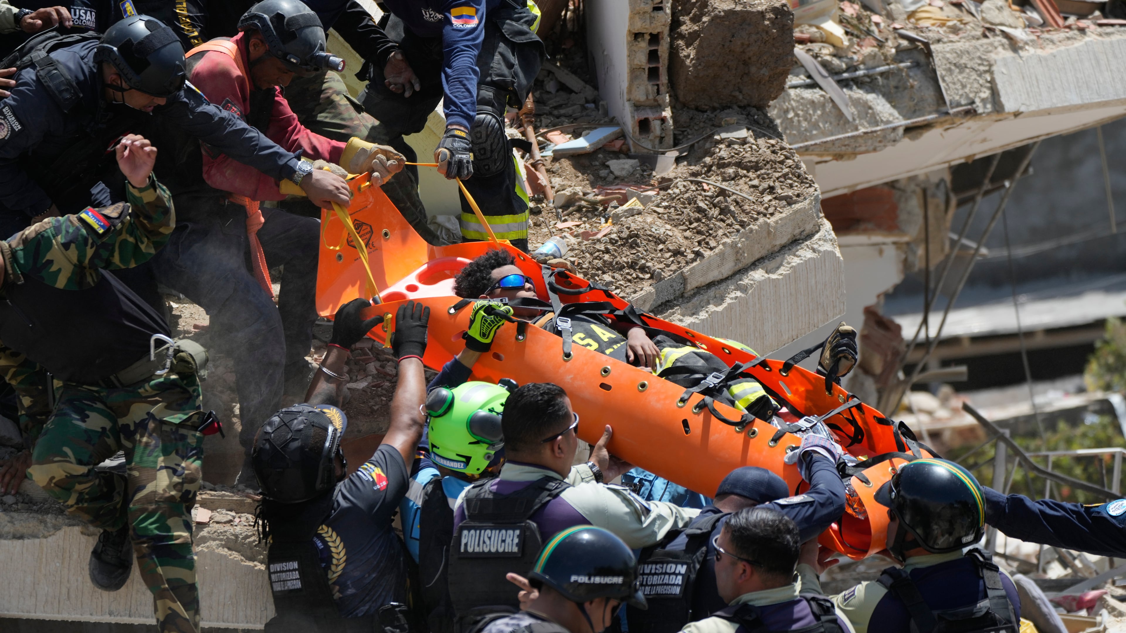 Rescue workers pull Moises Calzadilla, 11, from the rubble three days after earthquakes struck La Guaira, Venezuela, Saturday, June 27, 2026. (AP Photo/Fernando Vergara)