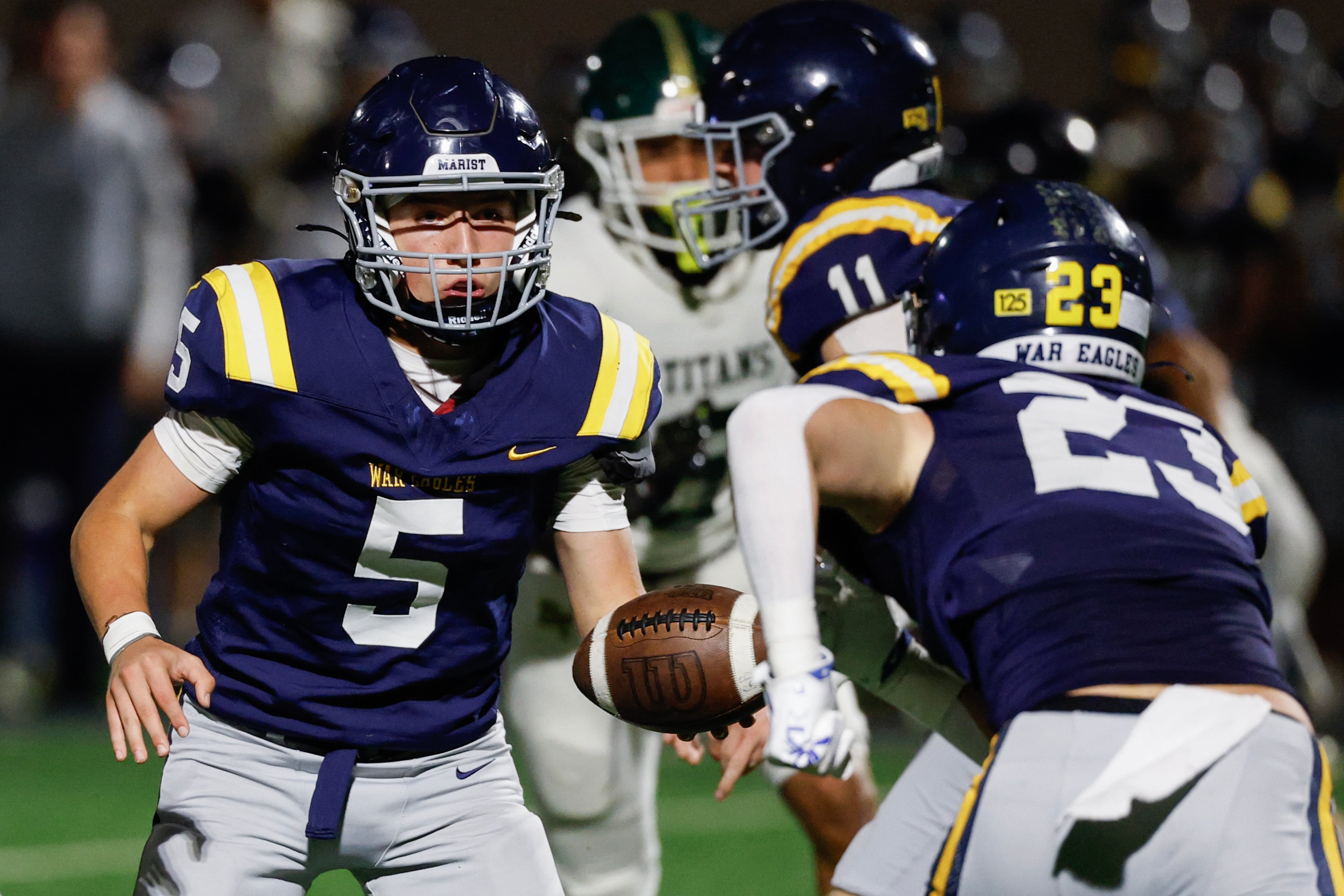 Marist quarterback Hayes Rollauer (left) hands off to running back Hudson Kalb during their game against Blessed Trinity on Friday, Sept. 25, 2026, in Atlanta. (Erik S. Lesser for the AJC)