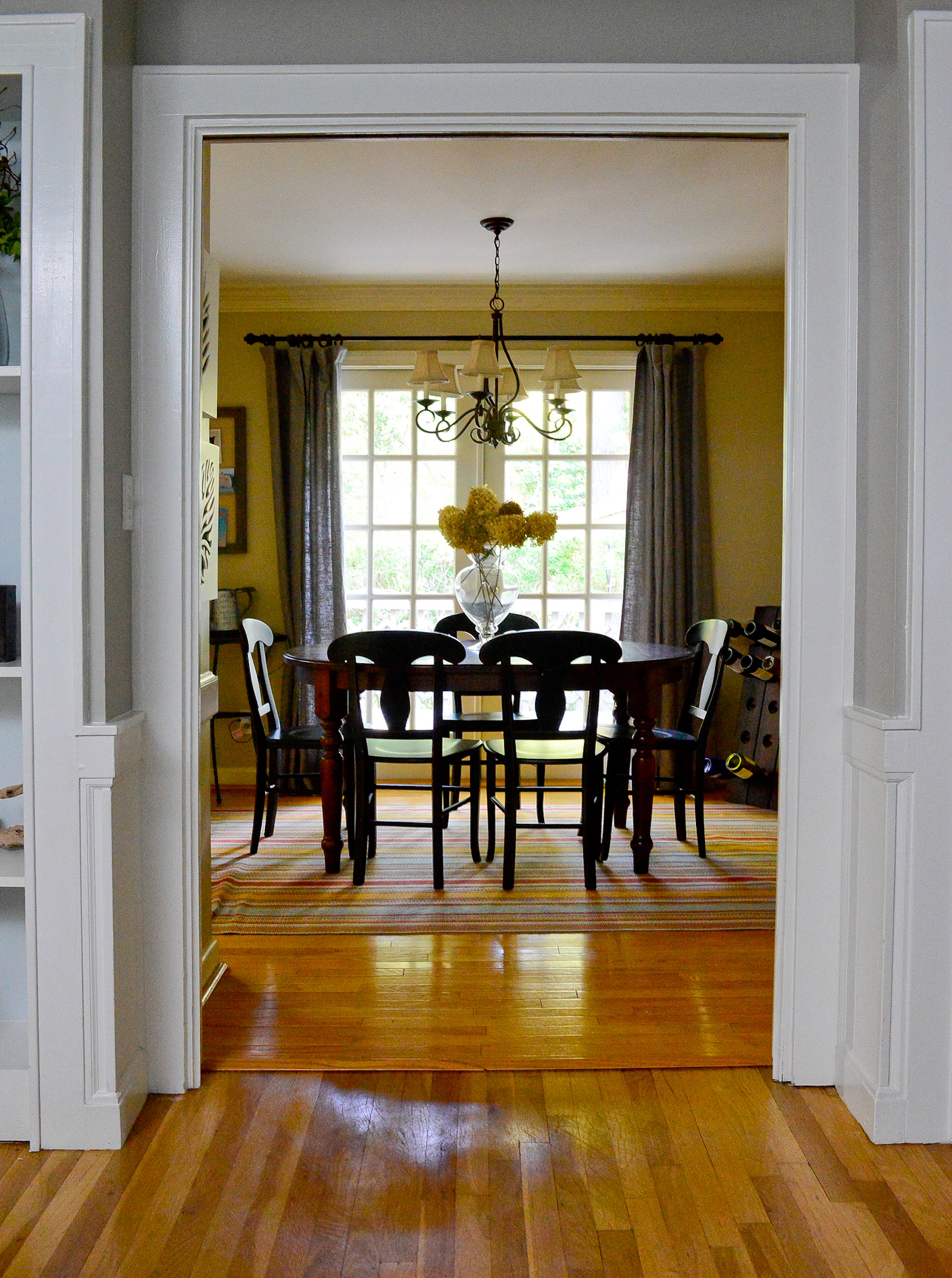 The home's Colonial style has a boxy design, but there is a large opening from the living room into the eat-in kitchen. The hardwood floors continue into the kitchen, with a table found on Craigslist.