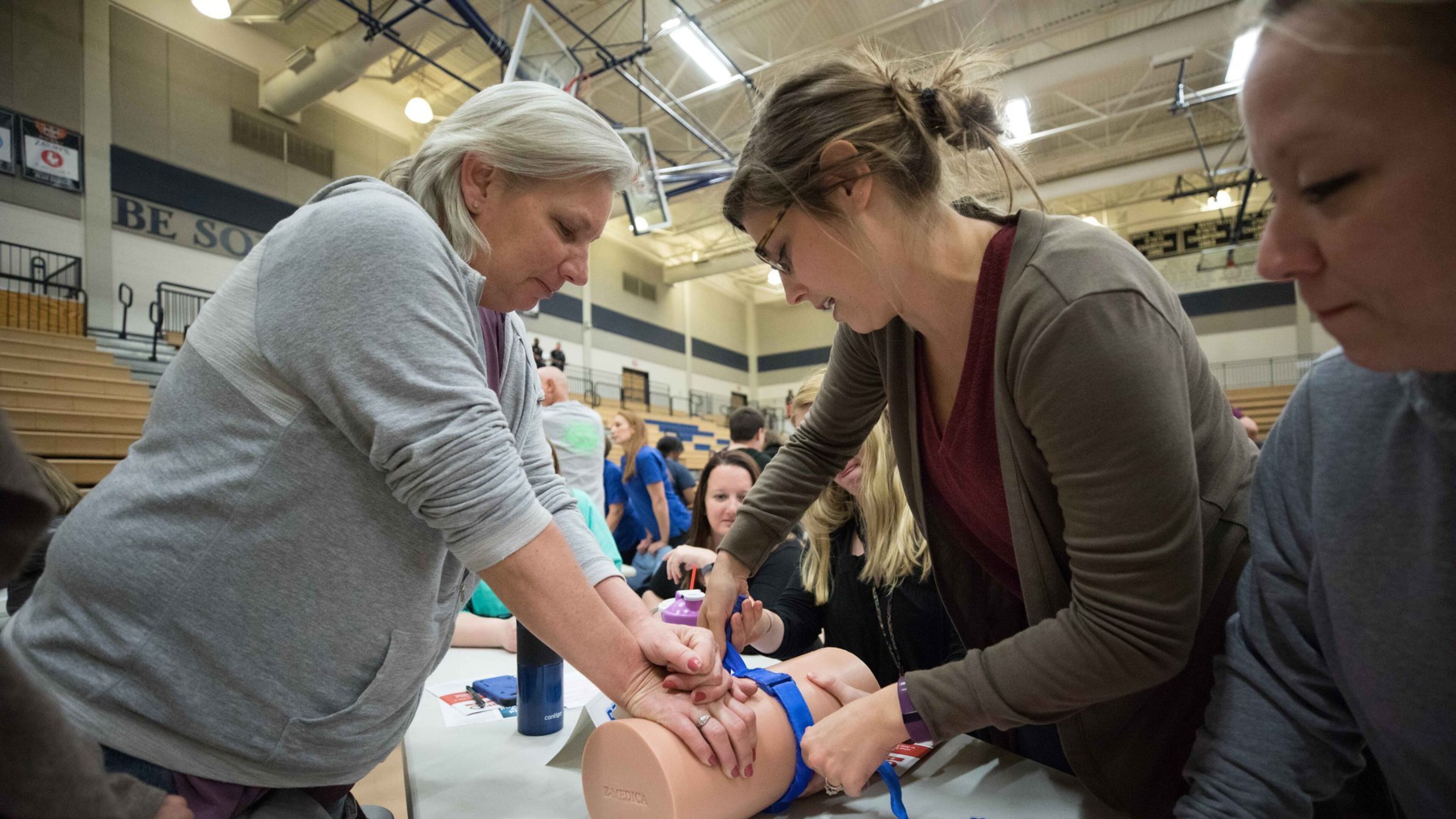 Nickajack elementary teachers Joan Lunsfurd, left, Callie Quinn, center, practice using a tourniquet as April Mitchell watches during an active shooter training seminar at Marietta High School, Monday, Feb. 26, 2018, in Marietta, Ga. BRANDEN CAMP/SPECIAL