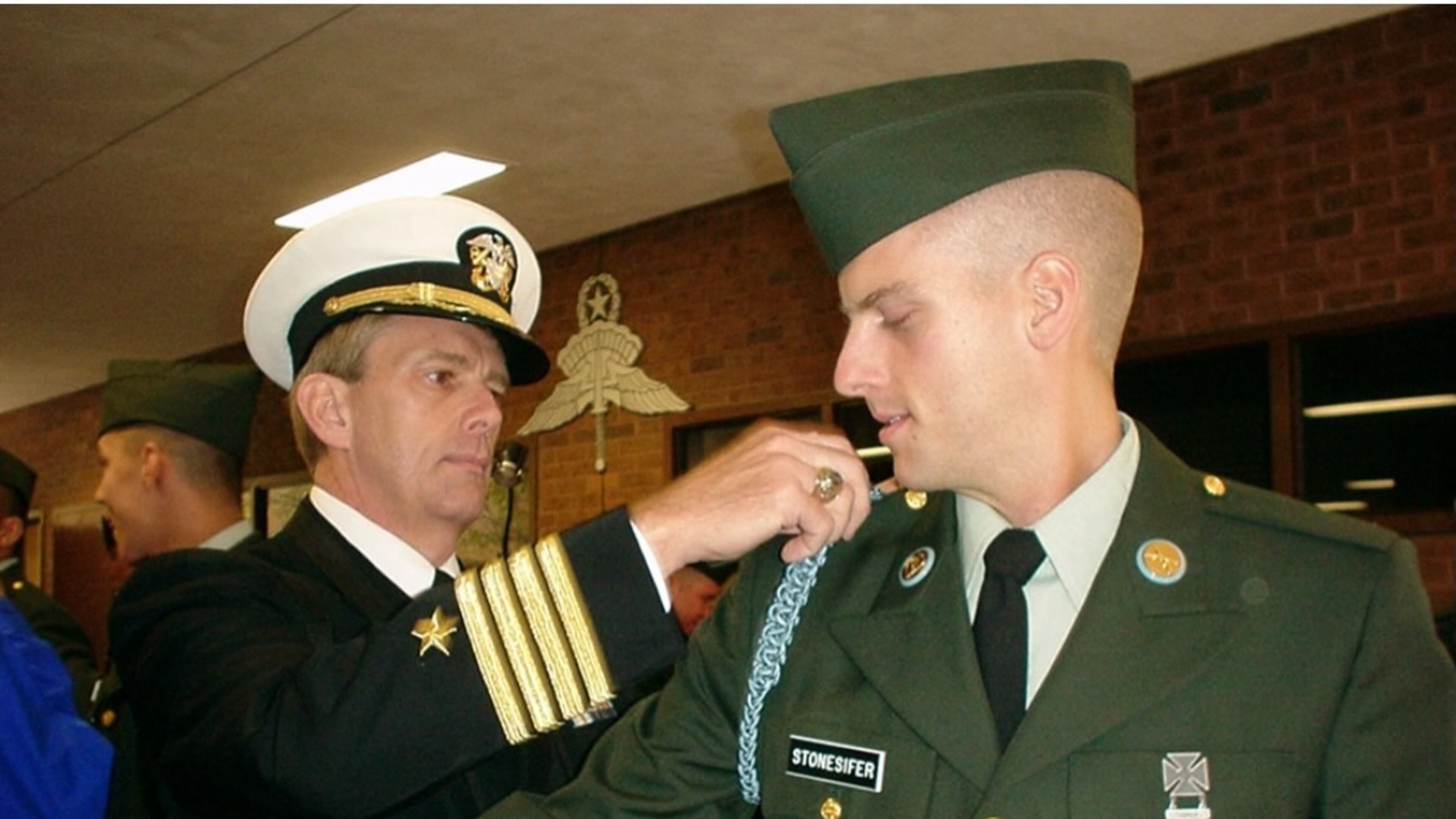 Ric Stonesifer attaches the shoulder cord to the uniform of his son Kristofor after graduating from infantry school at Fort Benning. (Courtesy of Stonesifer family)