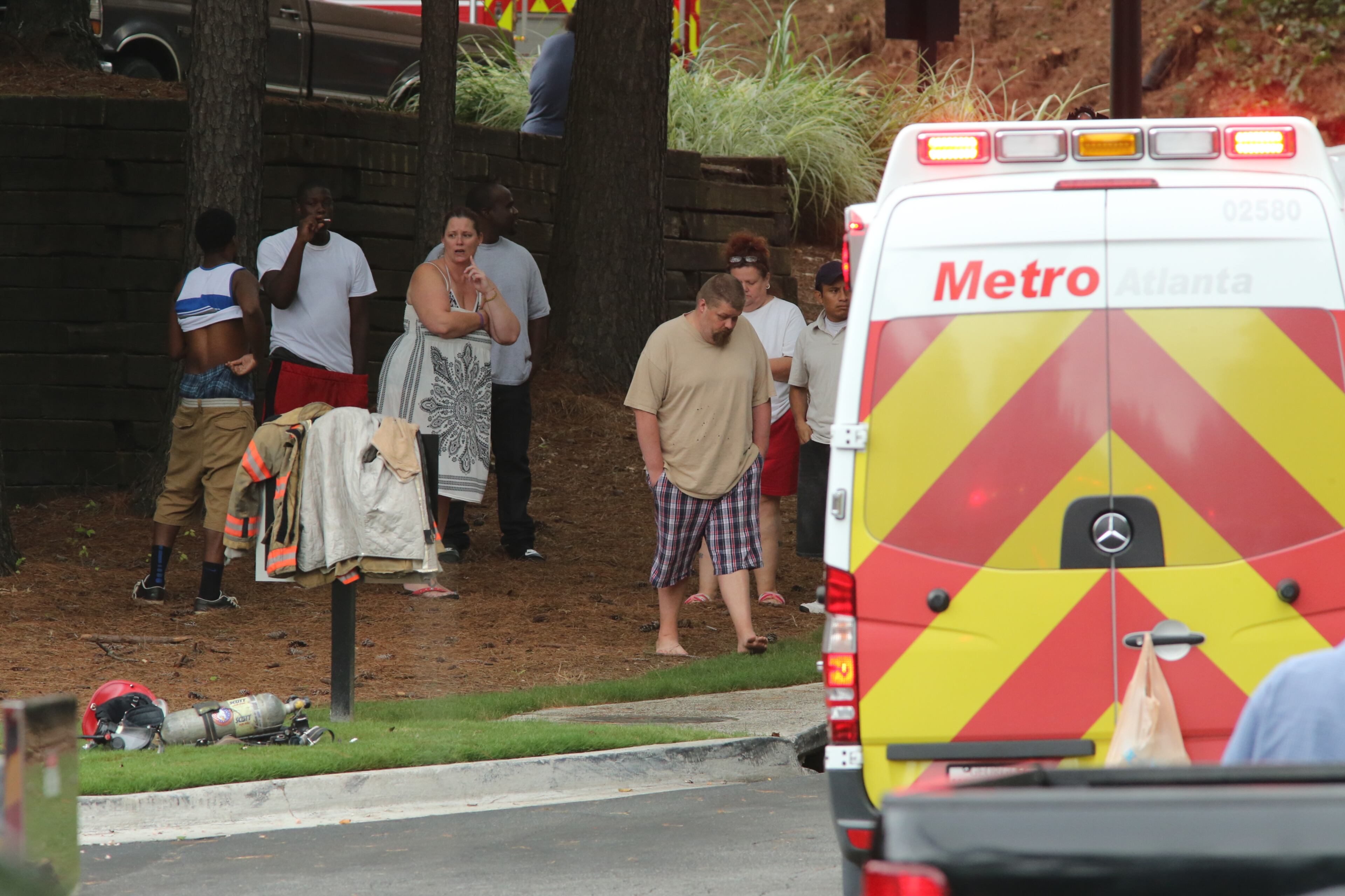 Residents watch Cobb firefighters respond to a blaze at an apartment building on Powder Springs Road just south of Marietta on Friday, August 16, 2013.
