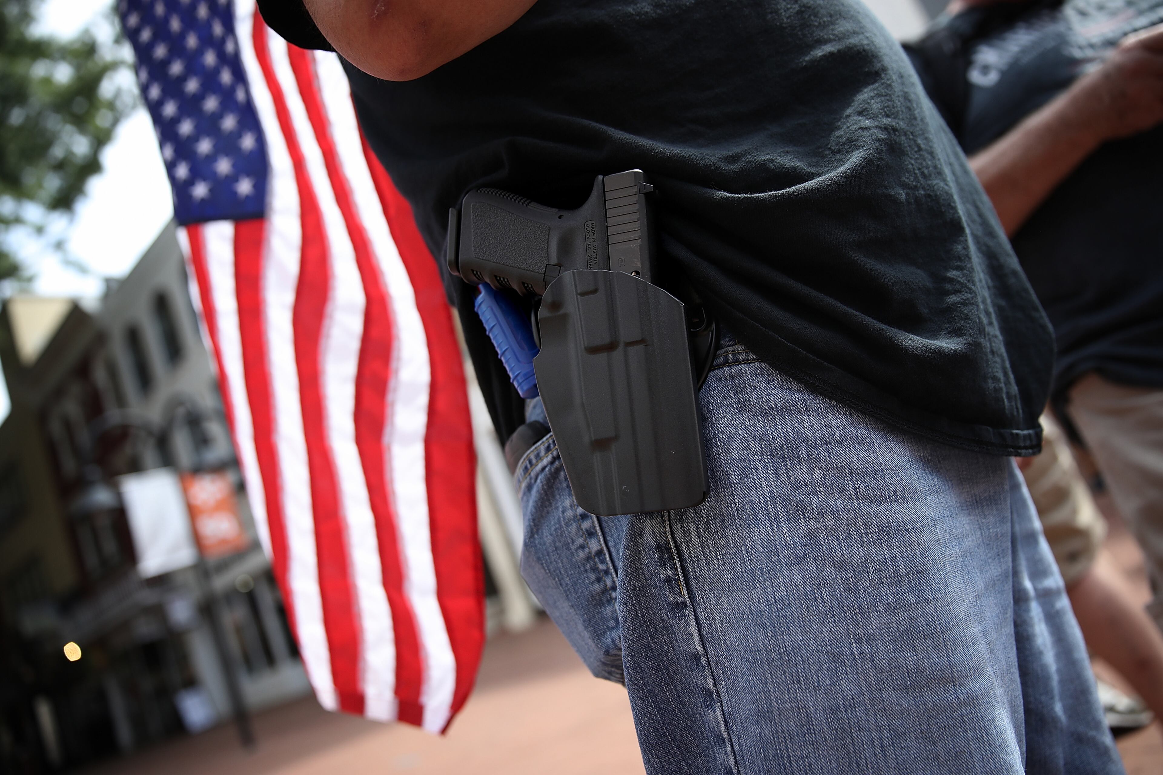 CHARLOTTESVILLE, VA - AUGUST 12: A protester wearing a pistol on his hip stands near the location where a car plowed into a crowd of protestors marching through a downtown shopping district August 12, 2017 in Charlottesville, Virginia. The car allegedly plowed through a crowd, and at least one person has died from the incident, following the shutdown of the 'Unite the Right' rally by police after white nationalists, neo-Nazis and members of the 'alt-right' and counter-protesters clashed near Lee Park, where a statue of Confederate General Robert E. Lee is slated to be removed. (Photo by Win McNamee/Getty Images)