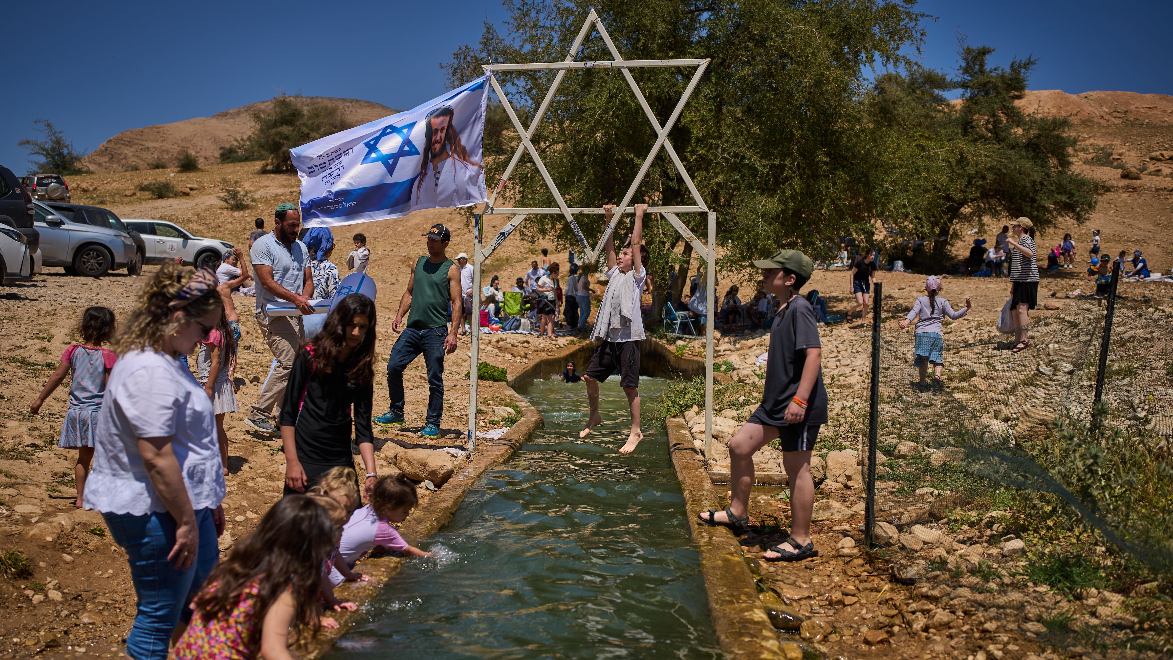 A child climbs on a metal Star of David structure at a spring in Auja, in the Jordan Valley, during Israel's Independence Day on April 22, 2026, in the occupied West Bank. (AP Photo/Ohad Zwigenberg)