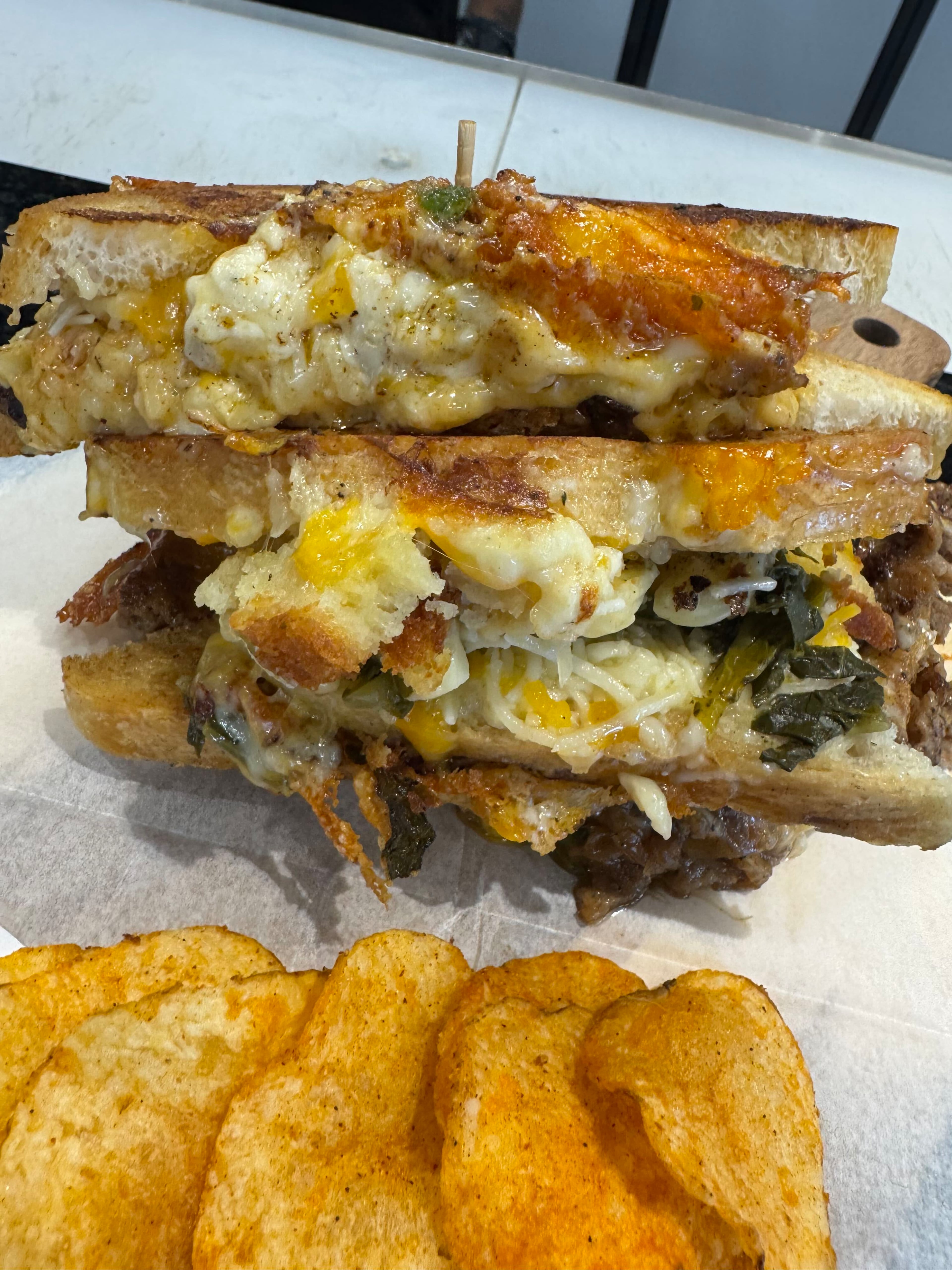 The Beltline sandwich at & Cheese incorporates mac and cheese, collard greens and cornbread in an already decadent sandwich. (Justin Brown for the AJC)