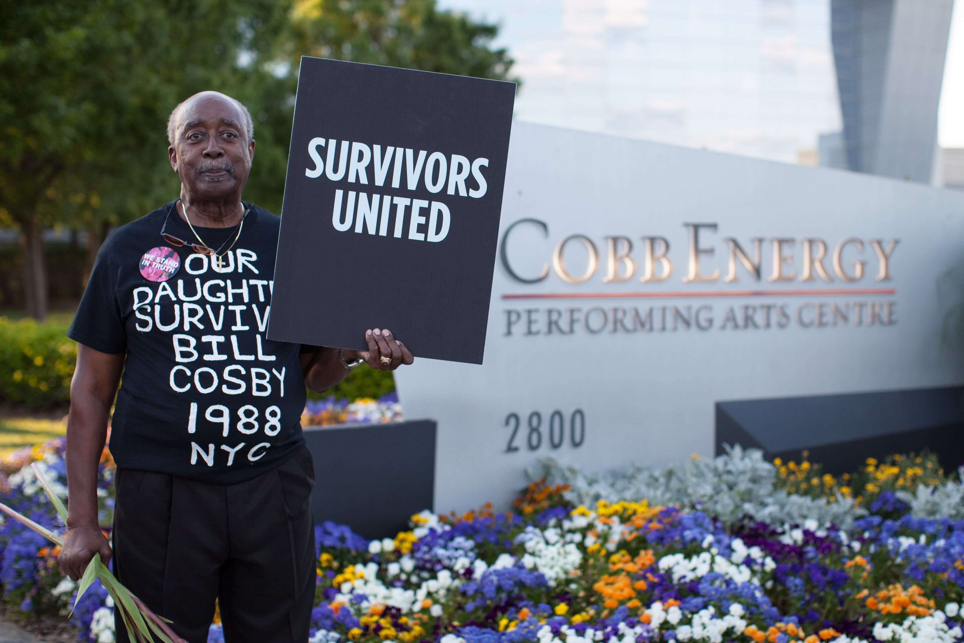 Bill Thompson, father of Kaya Thompson, who says Bill Cosby sexually assaulted her, holds a sign at the entrance of the Cobb Energy Performing Arts Centre, Saturday, May 2, 2015, in Atlanta, Ga. A group of protesters gathered to speak out against Cosby's performance after allegations that he sexually assaulted several women throughout his career. (SPECIAL/BRANDEN CAMP)