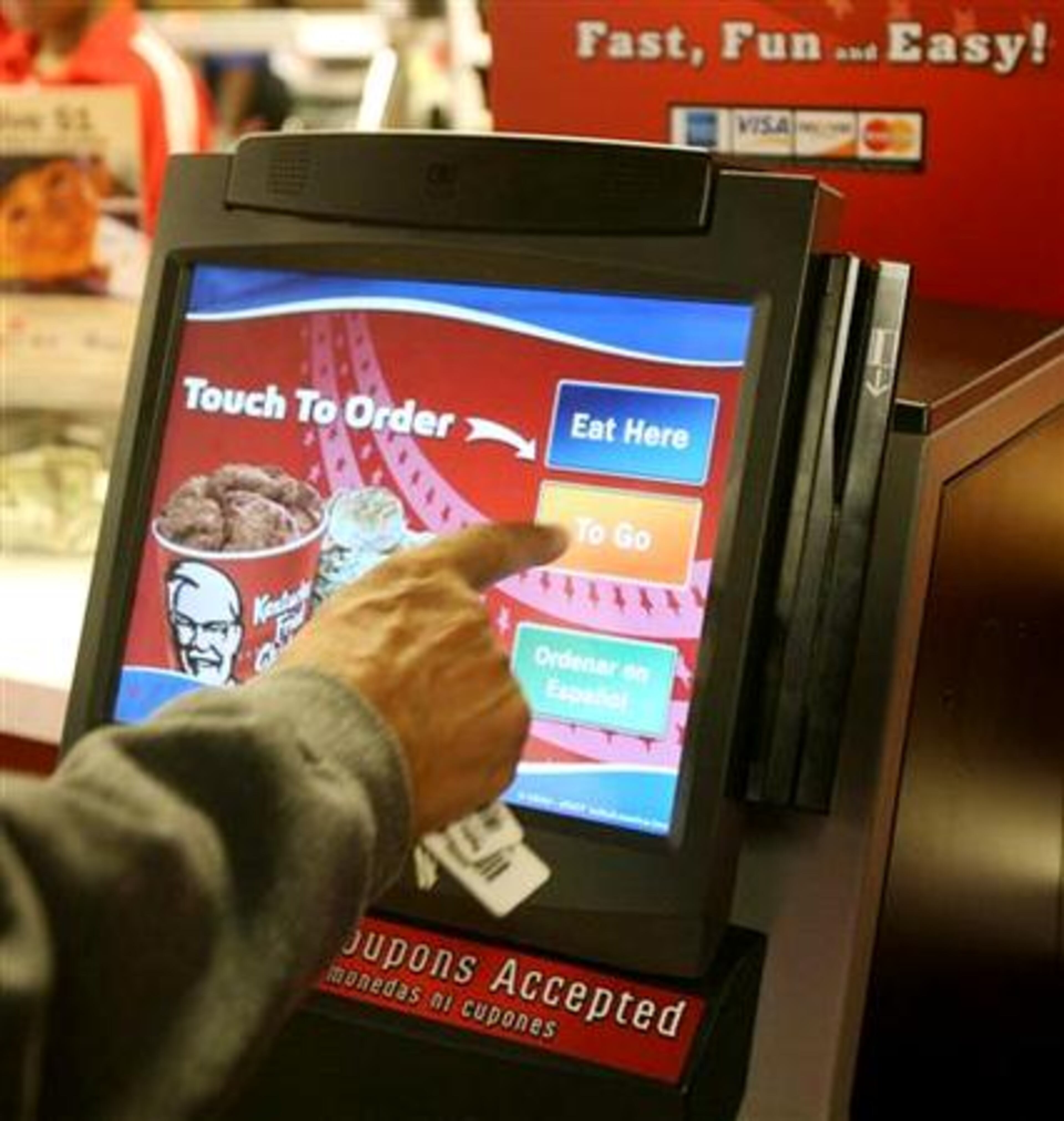 A customer places a self-service order to go on a kiosk as they order dinner at the Kentucky Fried Chicken on Hwy 138, Conyers, Ga., Tuesday, Oct. 16, 2007. The fast food restaurant is testing two self serve kiosks after the ATM culture has swept through the airline, grocery, and hotel industries.