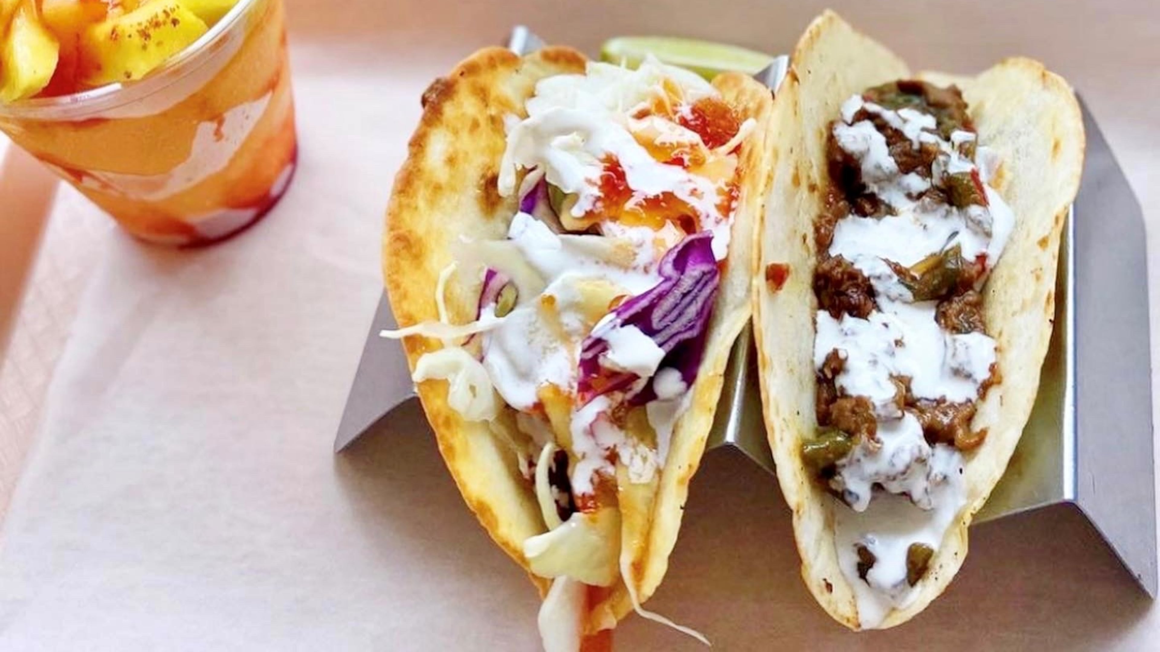 Chi Chi Vegan Taco Shop’s Mangonanda mango drink, with a Baja fish taco and a Philly cheesesteak taco. /
Credit: Tolli Marie