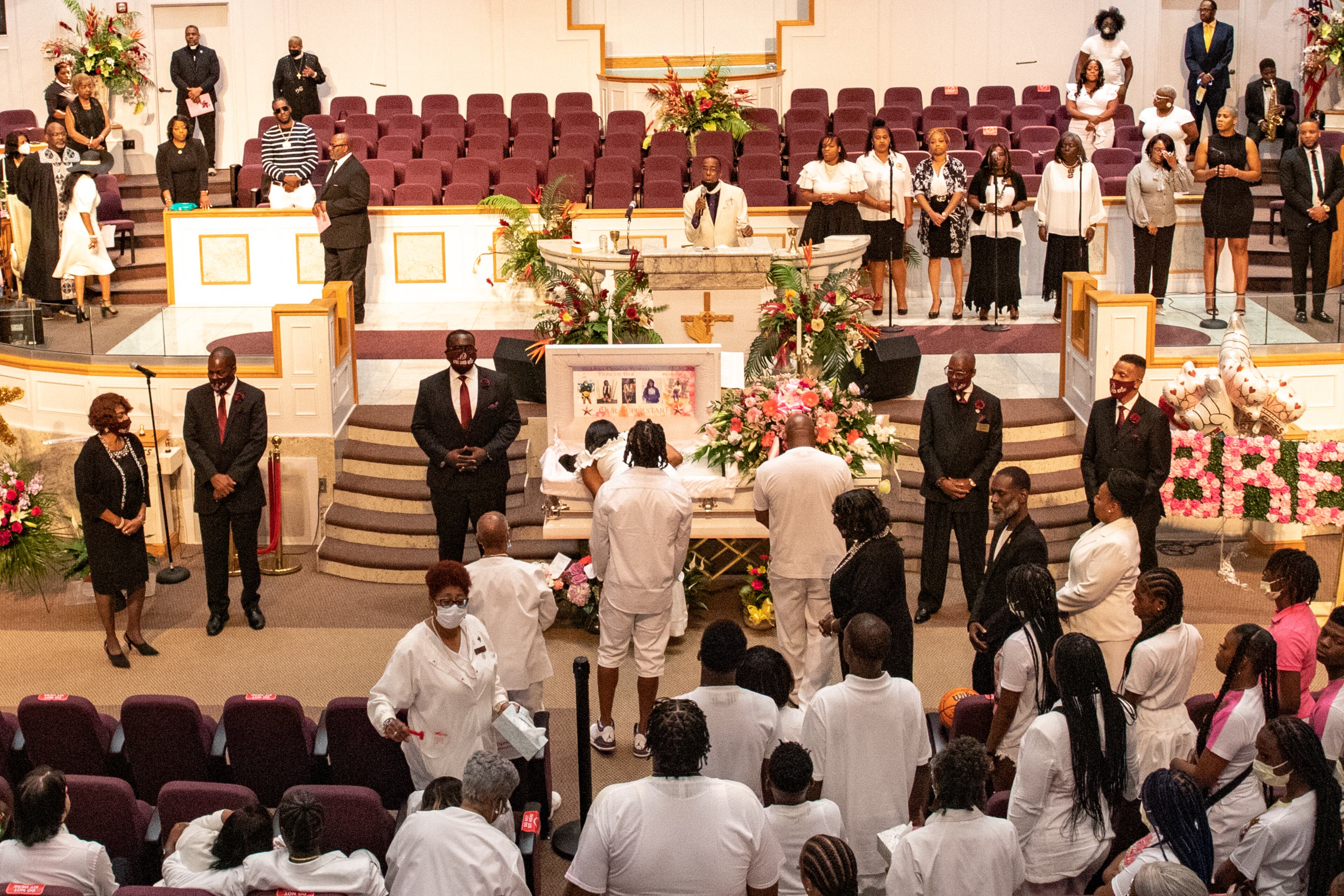 Shooting victim Bre’Asia Powell’s memorial service was held at Jackson Memorial Baptist Church in Atlanta on Saturday, June 3, 2023. Her mother, Nicole Williams, leans into the coffin to kiss and speak to her child. (Jenni Girtman for The Atlanta Journal-Constitution)