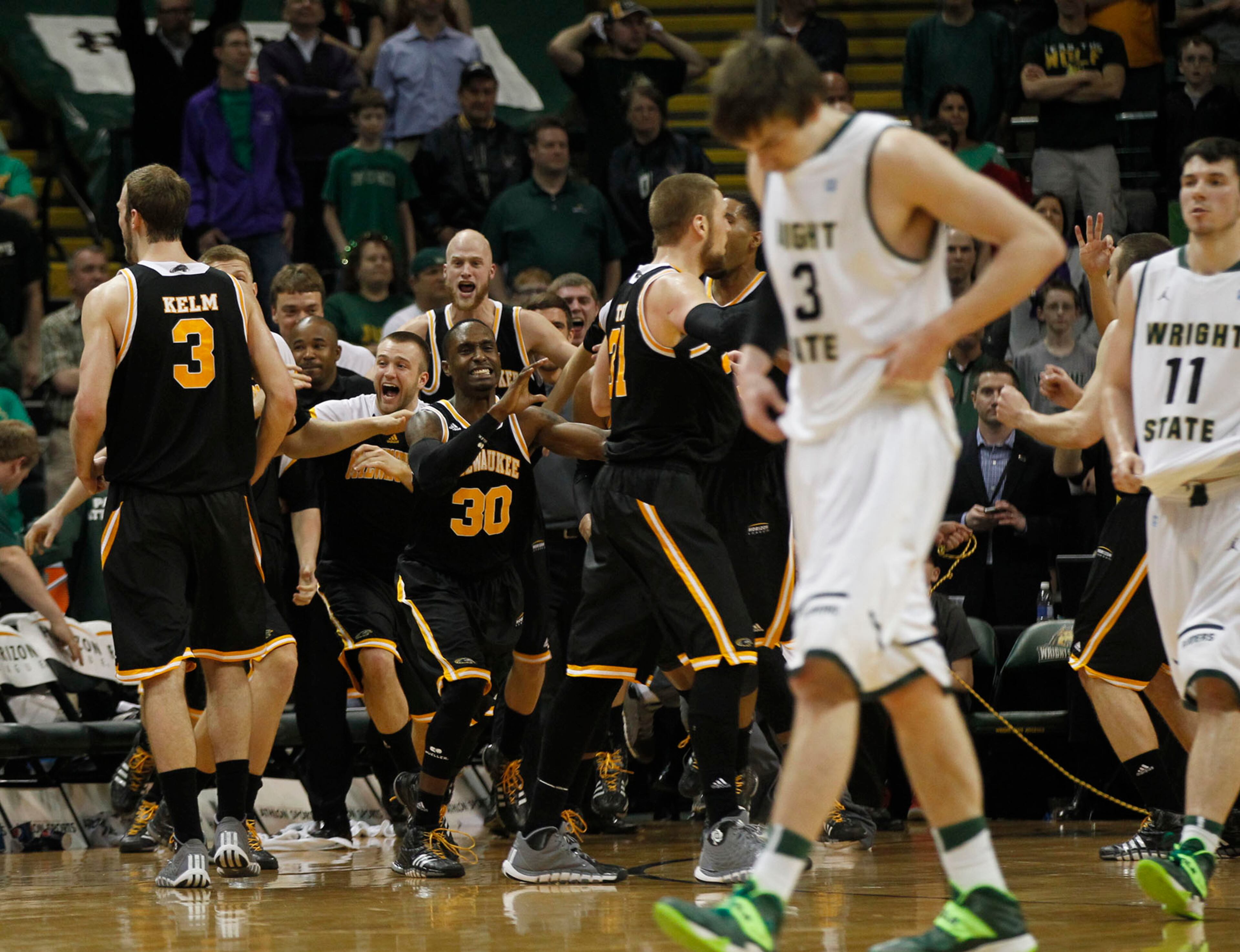 Milwaukee Panthers react as the clock ran out to defeat the Wright State Raiders 69-63 for the Horizon League Championship. Raiders Reggie Arceneaux and JT Yoho head for the locker room. TY GREENLEES / STAFF