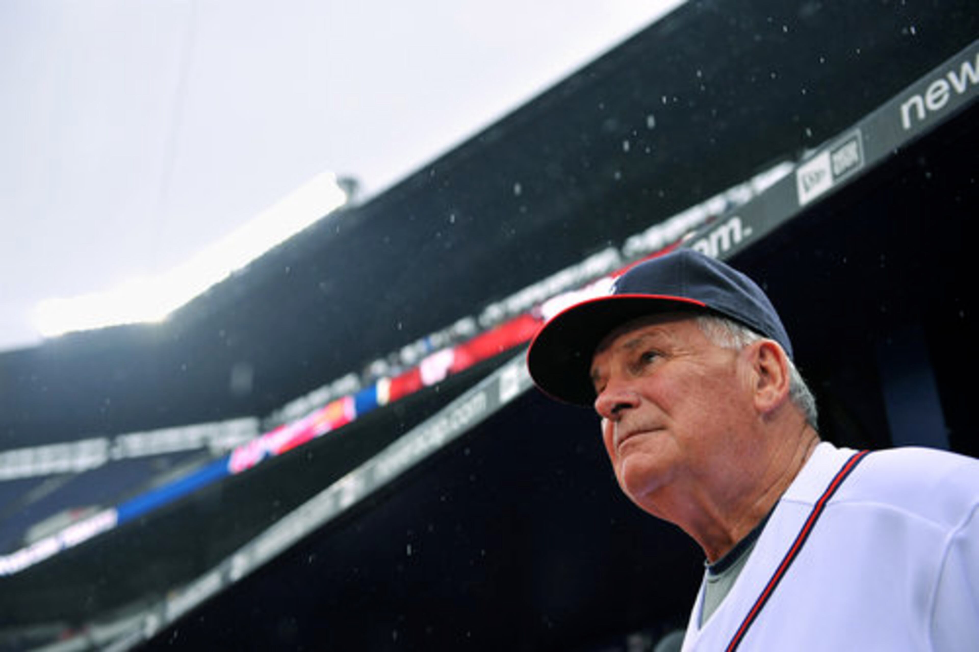 Braves manager Bobby Cox, who had filled out his lineup card, peeks out of the dugout, looking skyward one last time after the game was called.