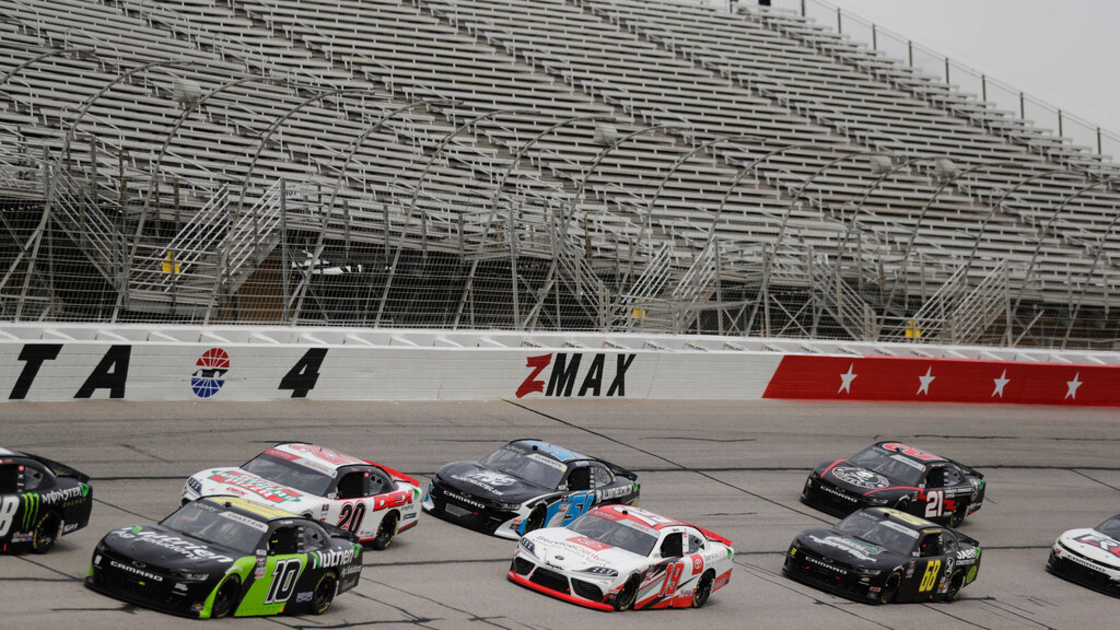 Cars drive by empty stands during a NASCAR Xfinity Series auto race at Atlanta Motor Speedway on Saturday, June 6, 2020, in Hampton, Ga. (AP Photo/Brynn Anderson)