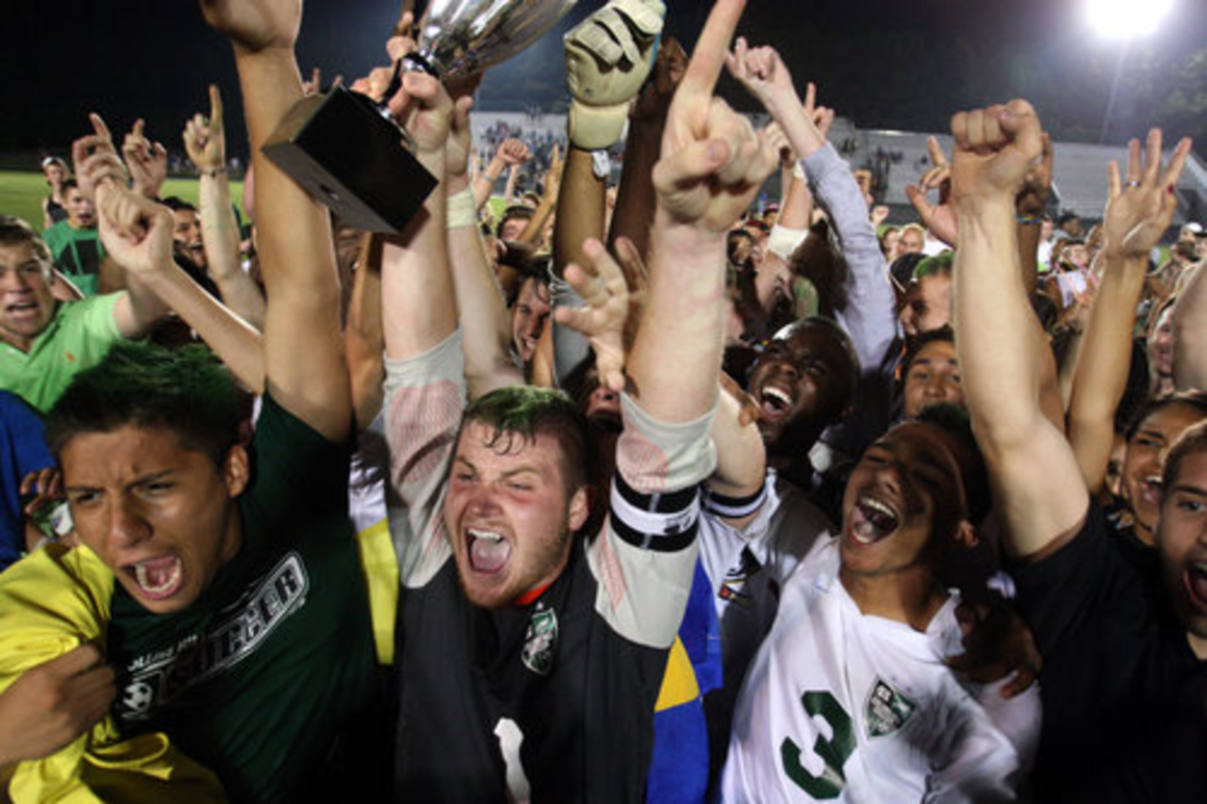 Collins Hill goalkeeper Jackson Taylor (1) lifts up the state championship trophy as he celebrates with teammates and fans after their 3-1 win over Centennial in the Class AAAAA boys soccer state championship game at Collins Hill High School Friday night in Suwanee, Ga., May 18, 2012.