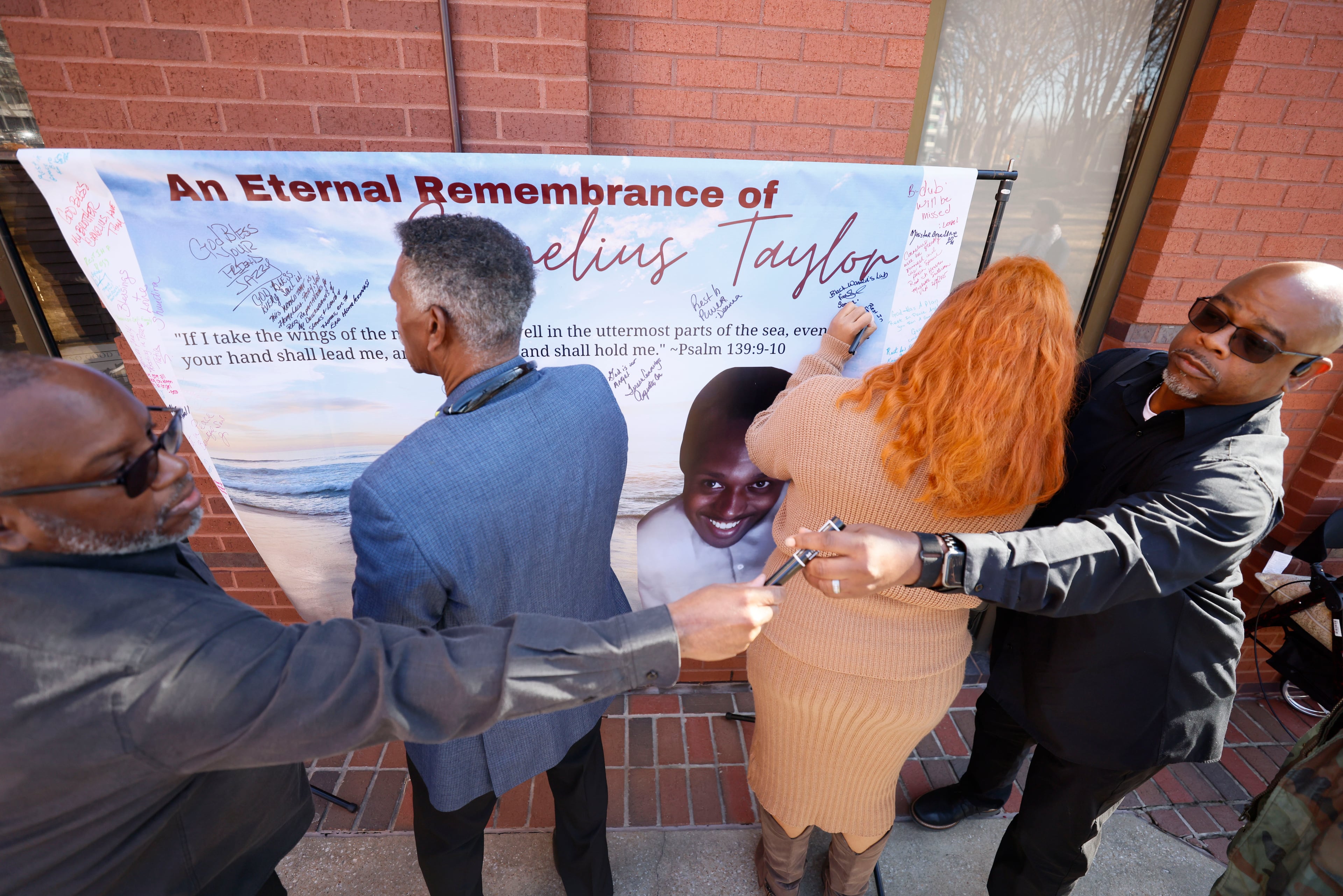 Attendees of the memorial service of Cornelius Taylor sign a remembrance banner before entering Ebenezer Baptist Church. (Miguel Martinez/AJC 2025)