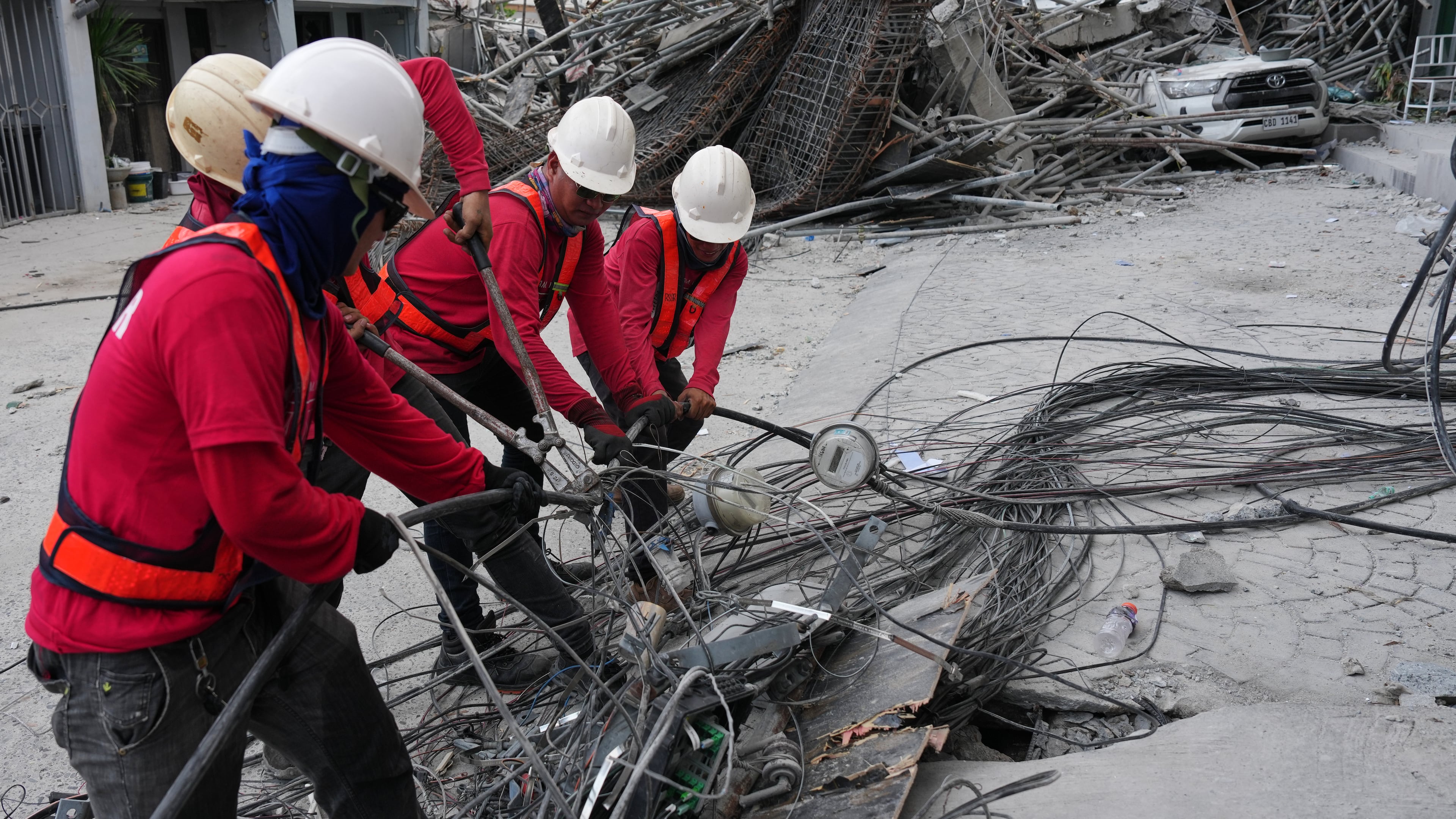 Workers cut cables during a search operation at a collapsed building where multiple people are believed to be trapped in Angeles city in Pampanga province, north of Manila, Philippines, Monday, May 25, 2026. (AP Photo/Aaron Favila)