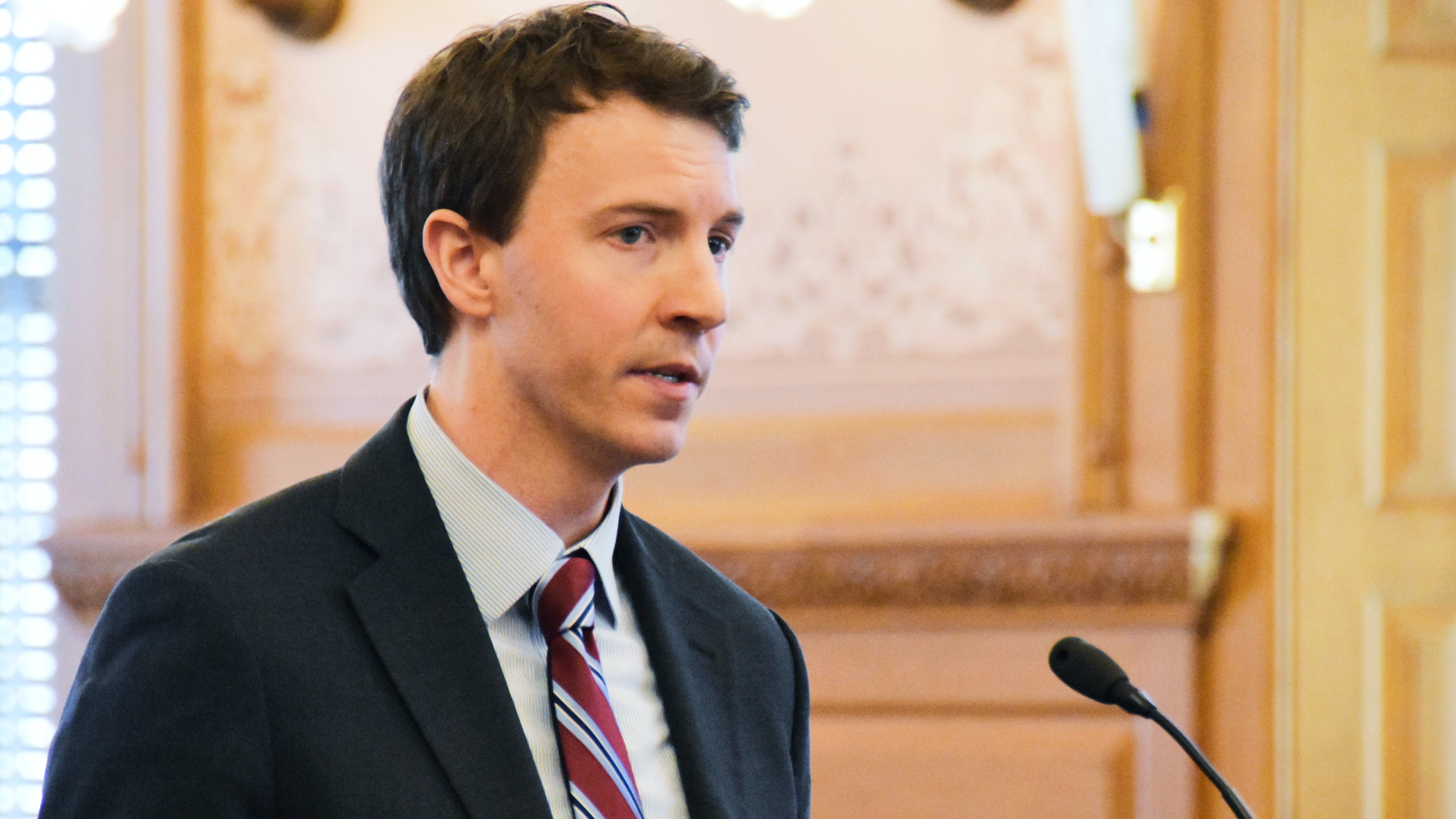 FILE - Bryan Seeley, a Major League Baseball senior vice president, testifies on a bill during a legislative committee hearing, March 13, 2018, at the Statehouse in Topeka, Kan. (AP Photo/Mitchell Willetts, File)