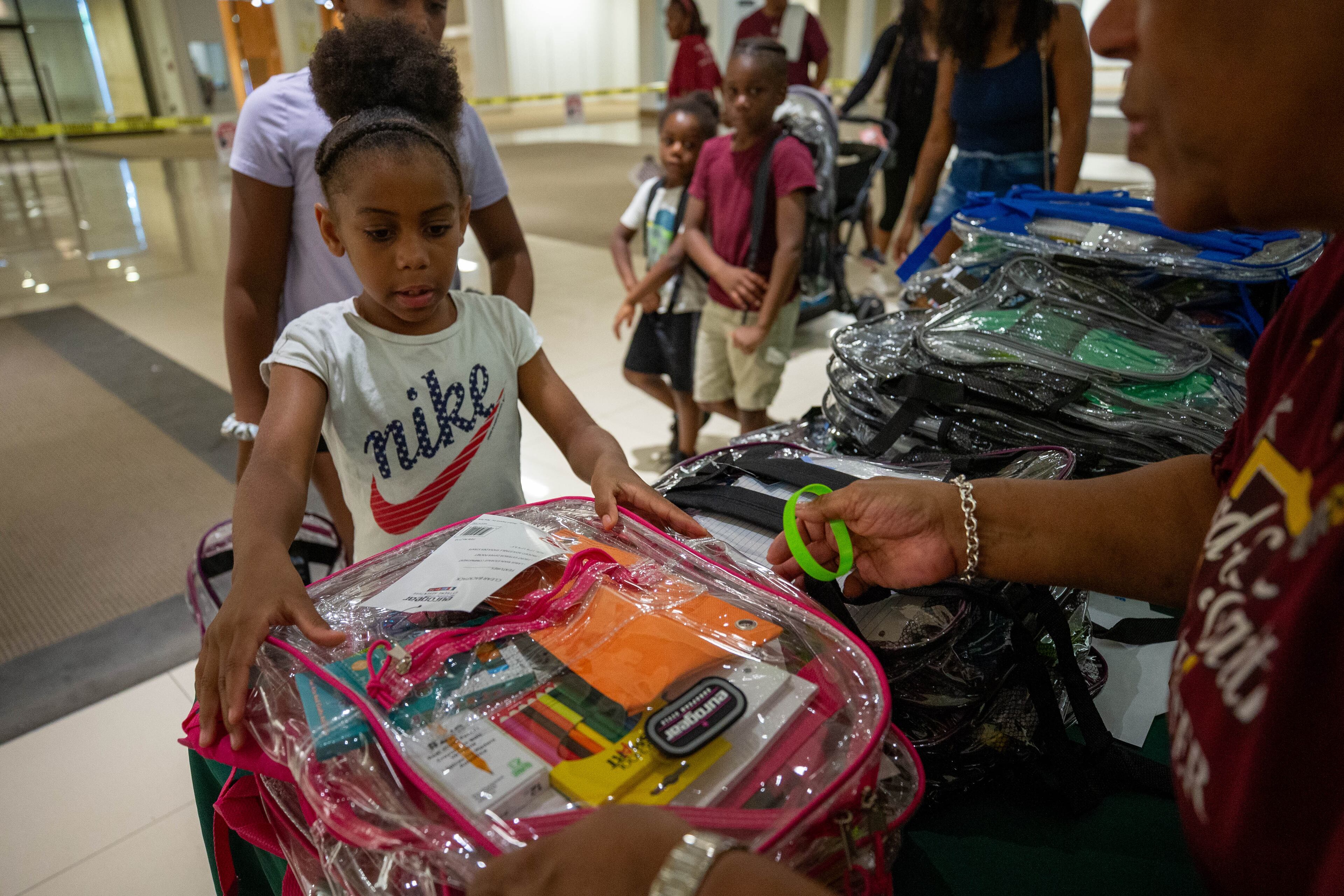 Makayla Smith receives a free school supply kit and clear backpack at the 20th annual Back-to-School Bash at Greenbriar Mall in Atlanta on Saturday, July 22, 2023. (Katelyn Myrick/katelyn.myrick@ajc.com)