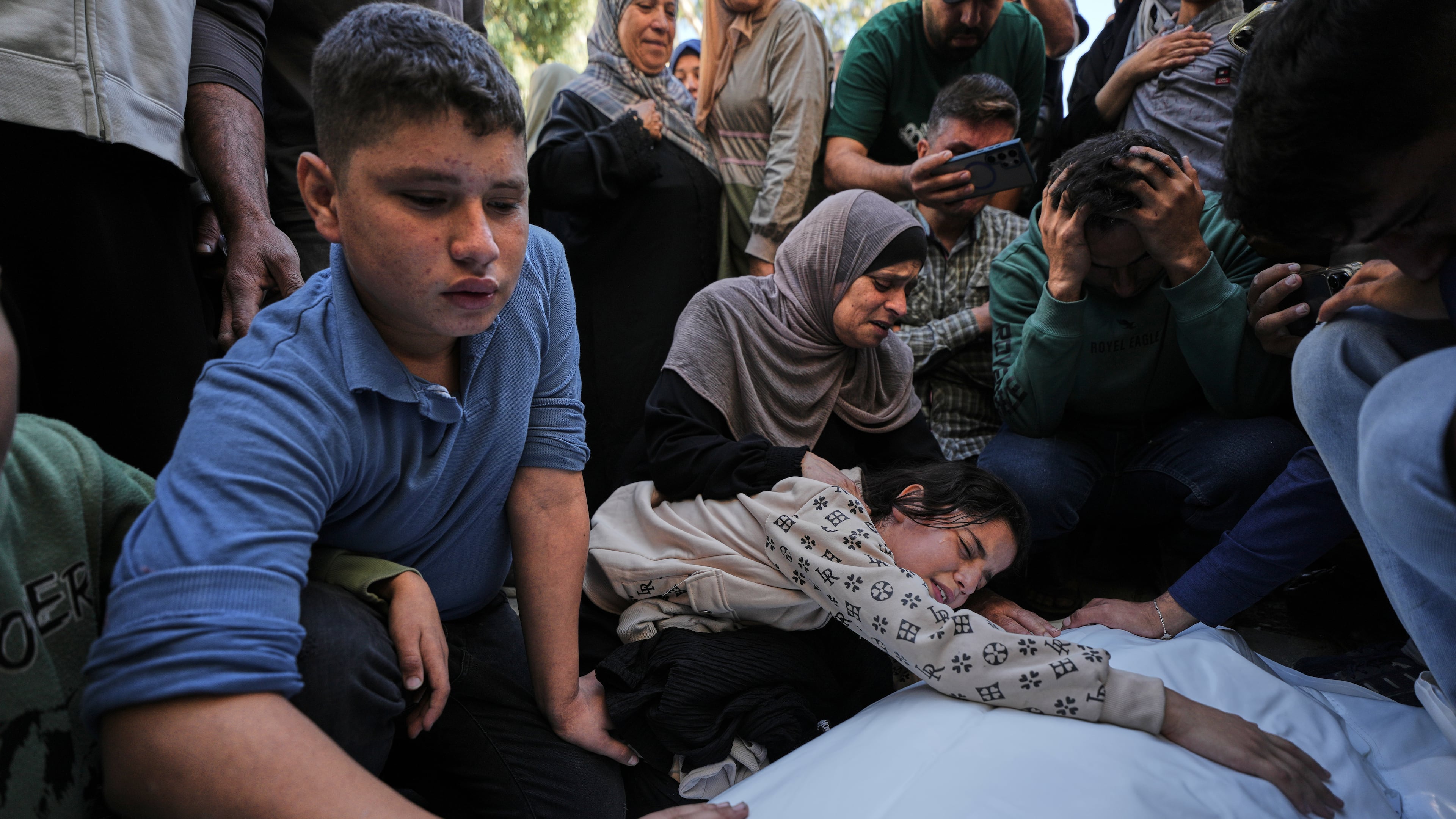 Dima Yassin mourns over the body of her mother, Dina Yassin, during the funeral of her parents, who were killed in an Israeli army strike on an apartment in Gaza City, Tuesday, Oct. 20, 2026. (AP Photo/Jehad Alshrafi)