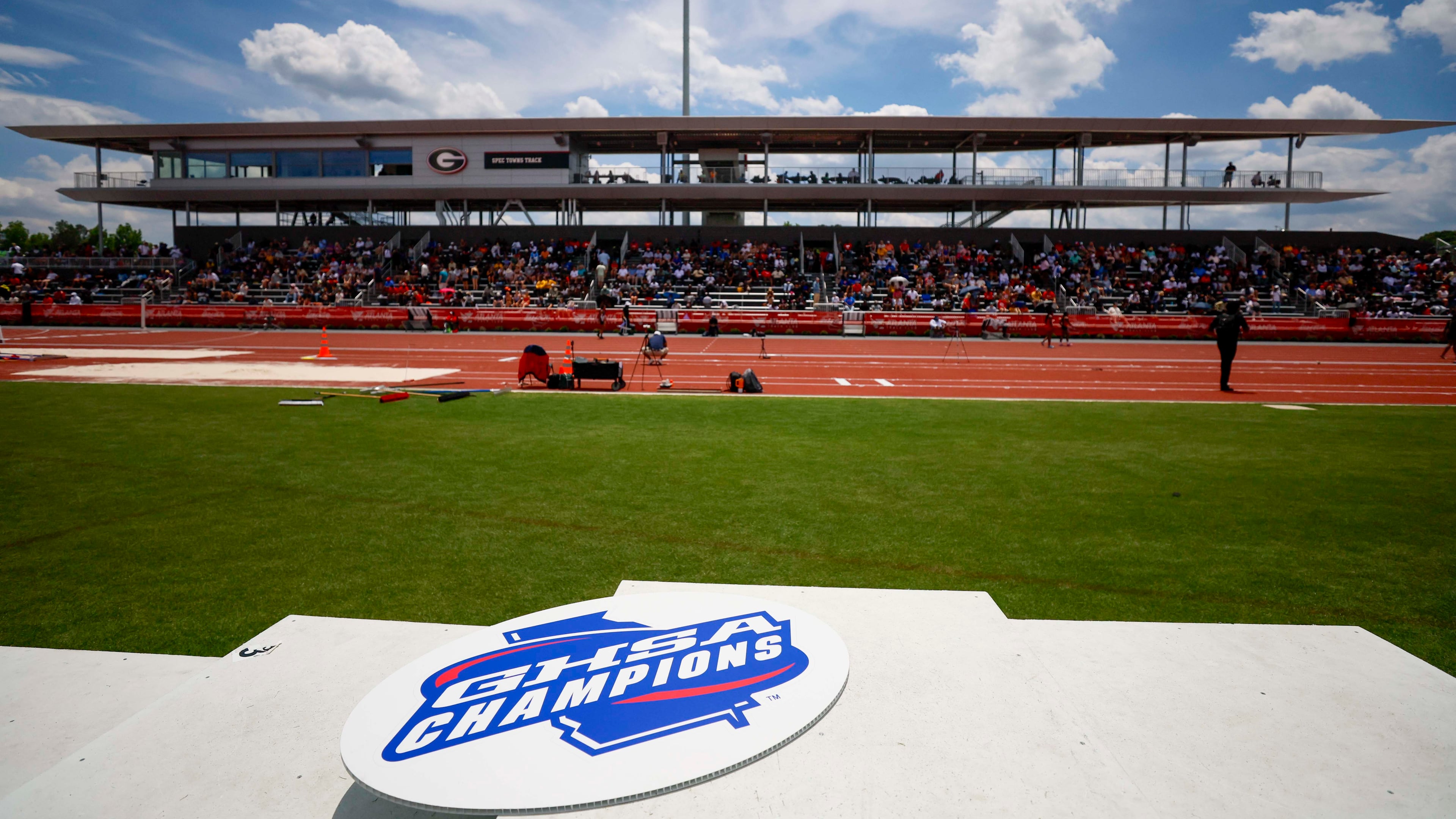 A GHSA logo is seen on the athletes’ podium during the boys 1,600 meters at the Class A Division II GHSA track and field state championships Monday, May 11, 2026, at Spec Towns Track at the University of Georgia in Athens. (Miguel Martinez/AJC)